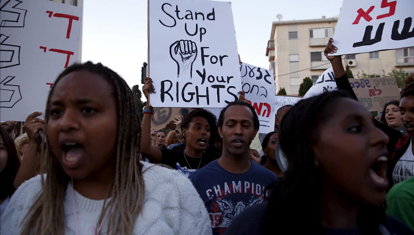 Israelis of Ethiopian descent hold signs during a protest against police brutality and racism in the northern city of Haifa, Israel May 12, 2015. -- PHOTO: REUTERS