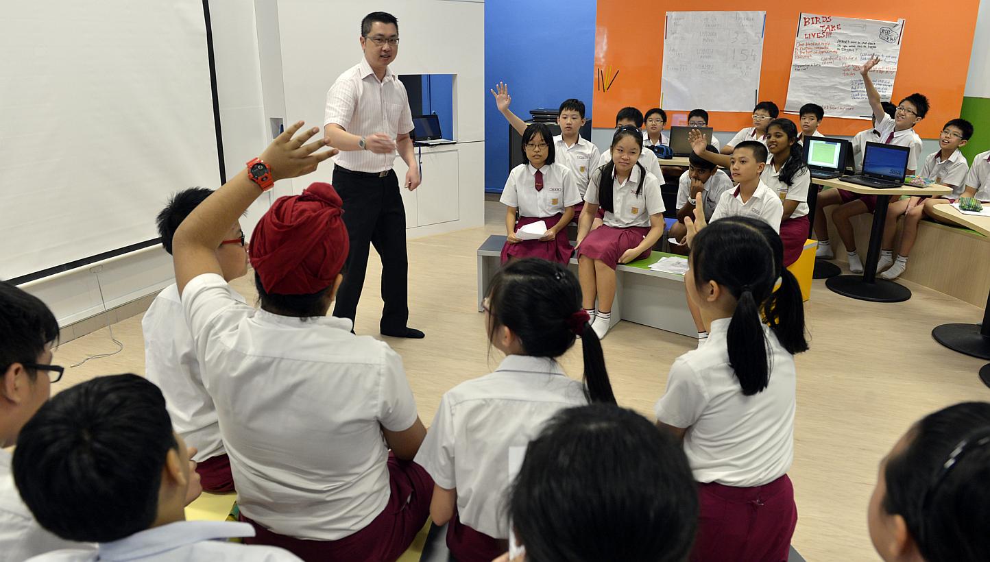 A teacher conducting a lesson with a class of Primary 6 pupils at Woodlands Primary School in 2012. Singapore has once again topped the biggest global school rankings published by the Organisation for Economic Co-operation and Development. -- PHOTO: