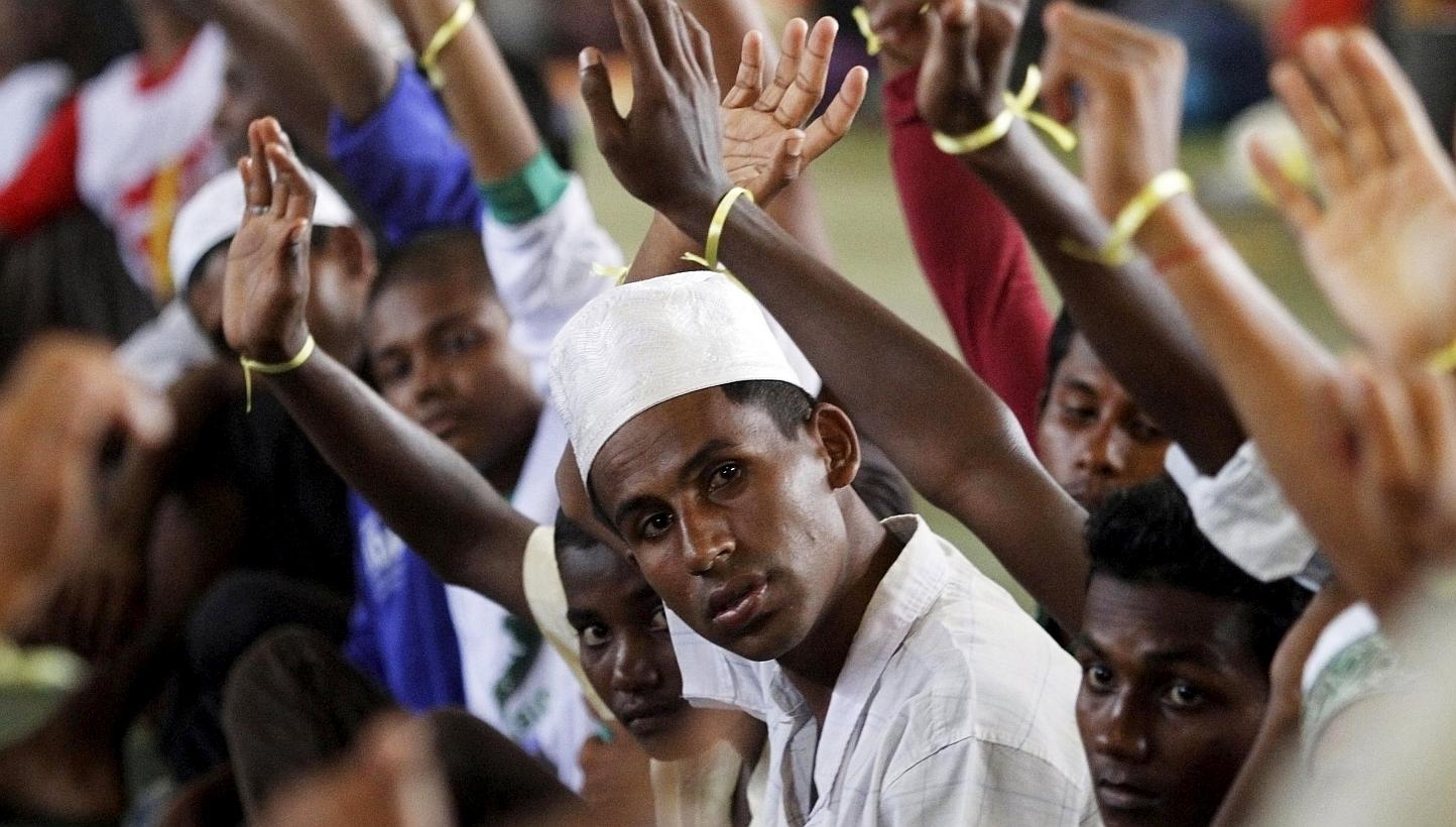 Migrants, believed to be Rohingya, raising their hands during an inspection at a shelter in Lhoksukon, in Indonesia's Aceh Province, on May 12, 2015. -- PHOTO: REUTERS