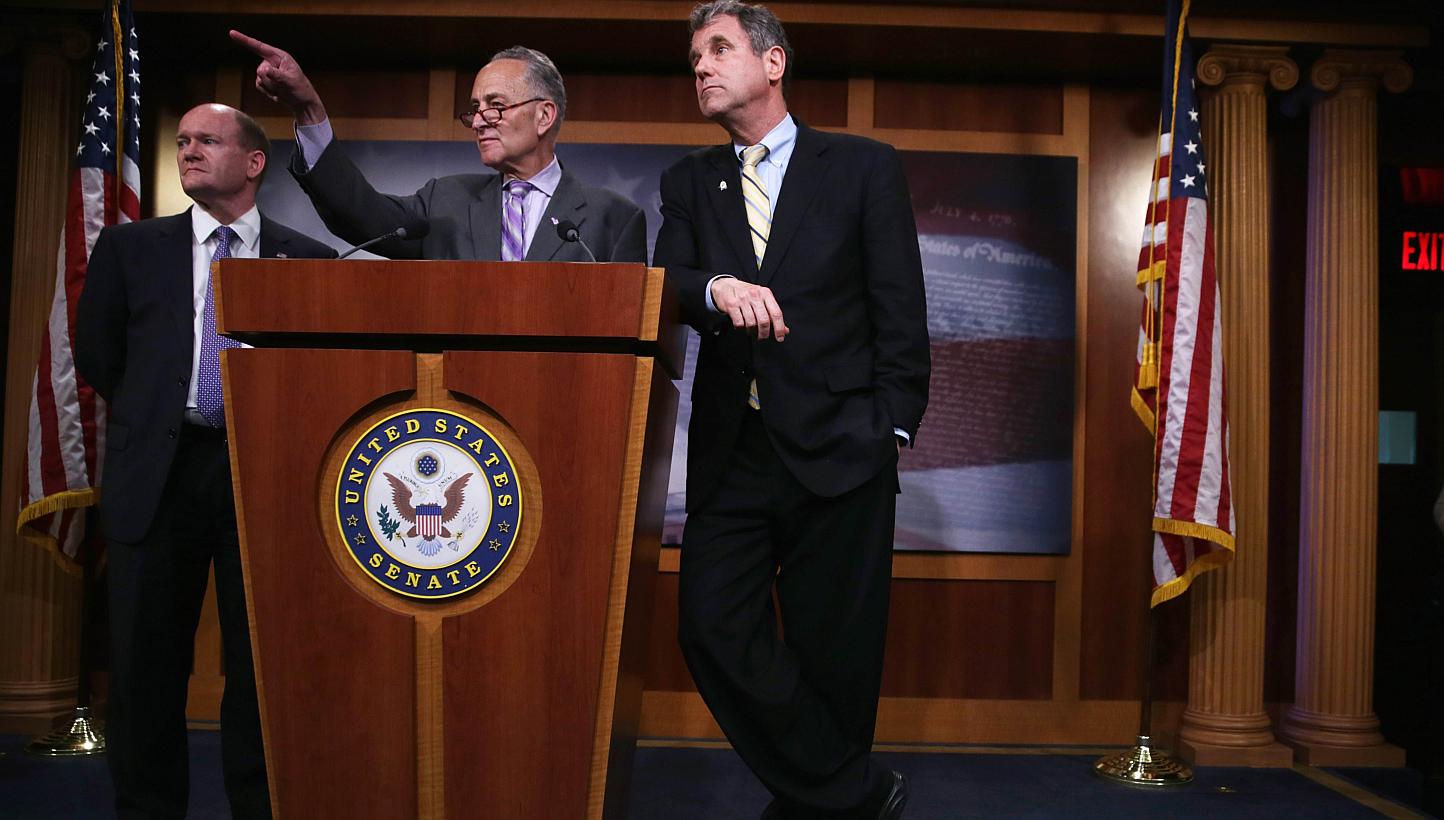 US Senator Charles Schumer (D-NY) taking questions as Senator Sherrod Brown (D-OH) (right), and Senator Chris Coons (D-DE) (left) look on during a news conference on May 12, 2015, on Capitol Hill in Washington, DC. US senators reached a deal Wednesda