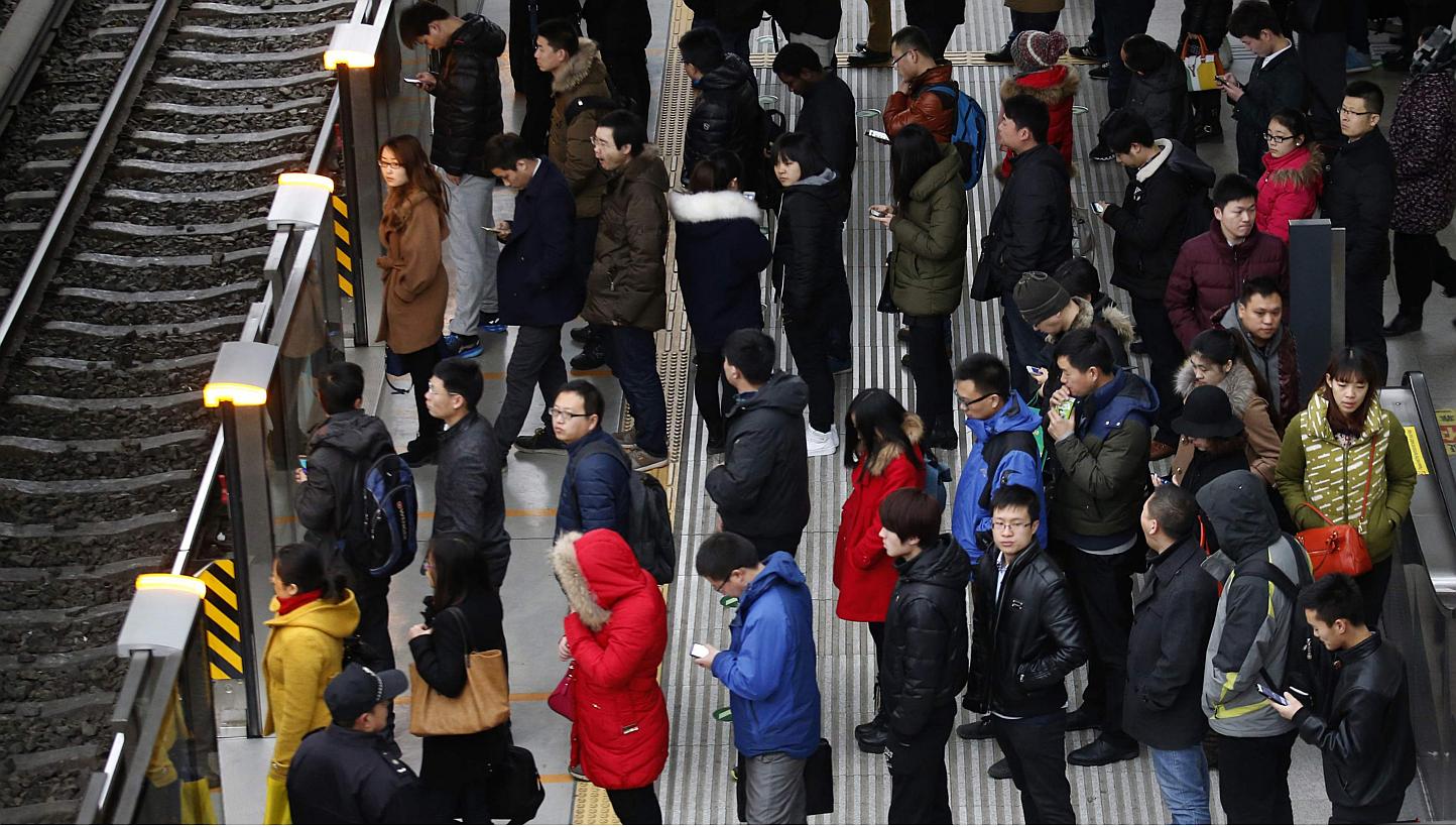 Passengers waiting for a train in Beijing on Feb 25, 2015. Beijing police are patrolling the city's subways and trains to stop people wearing face masks, strange costumes and forming flash mobs, warning commuters that such actions could jeopardise pu