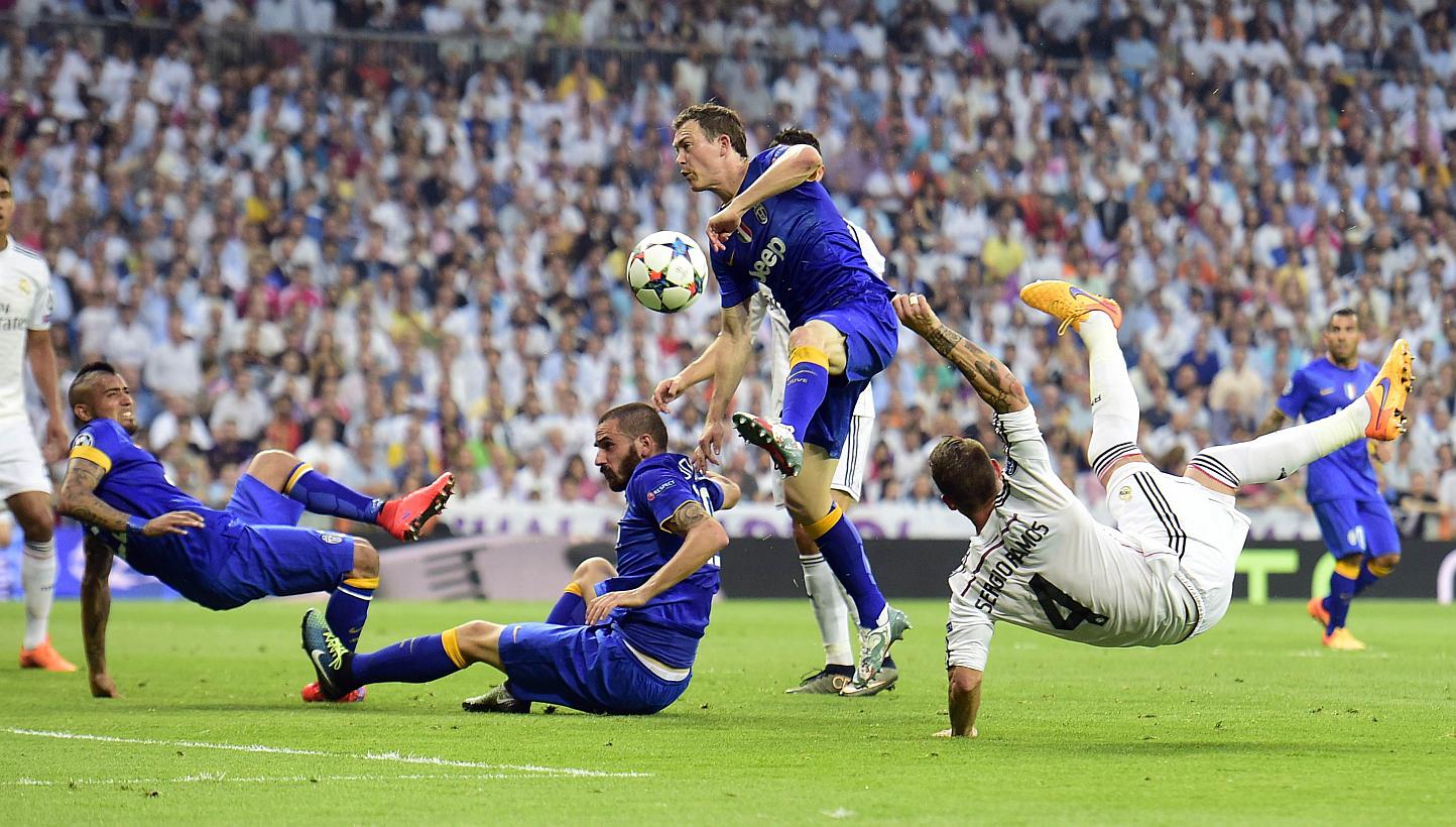 Real Madrid defender Sergio Ramos (right) kicks the ball past Juventus defenders Leonardo Bonucci (second left) and Stephan Lichtsteiner (second right) and midfielder Arturo Vidal during the Champions League semi-final on May 13, 2015. -- PHOTO: AFP&