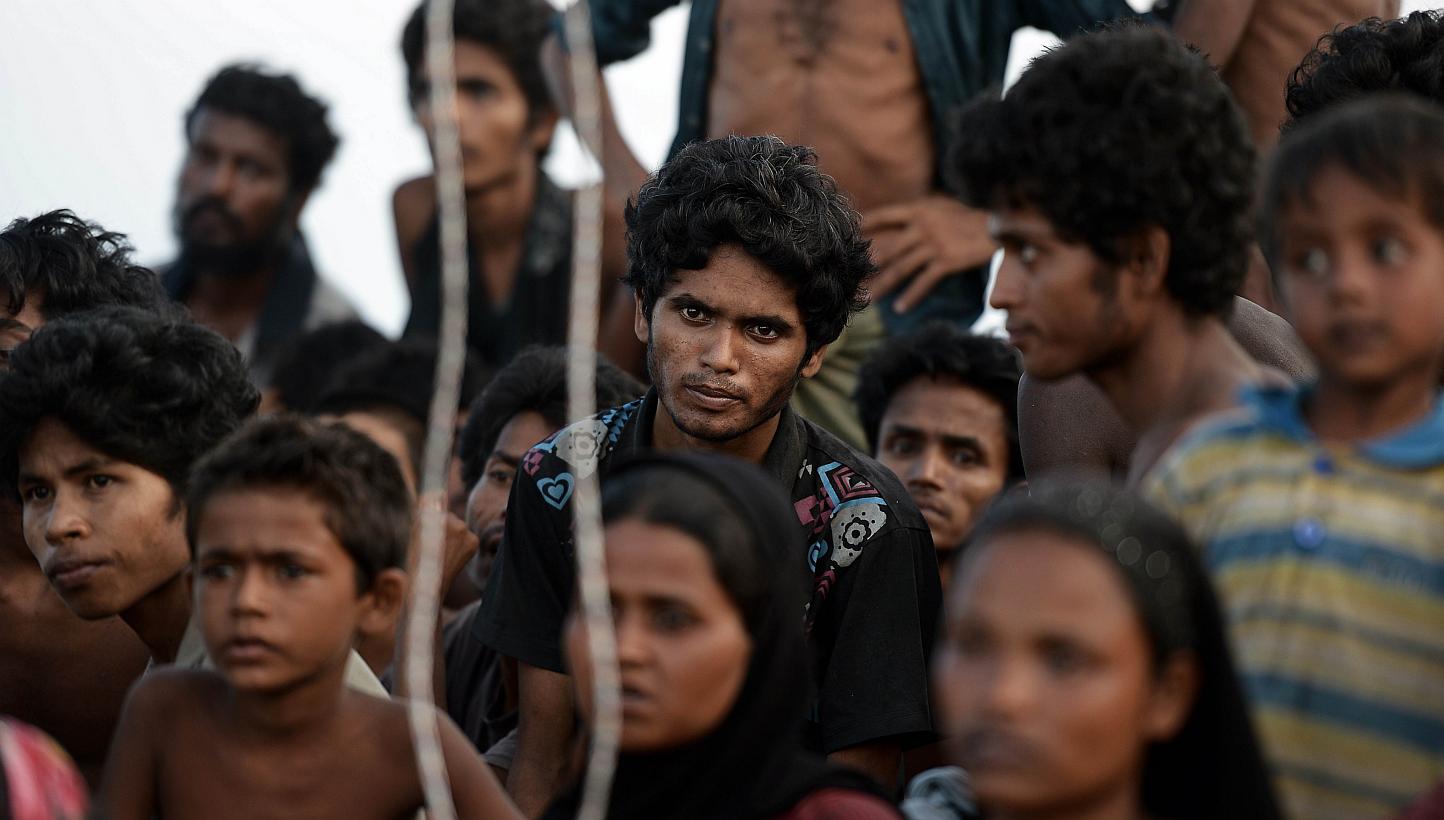 Rohingya migrants sitting in a boat drifting in Thai waters off the southern island of Koh Lipe in the Andaman. Trafficking experts say Thailand is the centre of a multi-million-dollar trade run by competing transnational criminal syndicates. -- PHOT