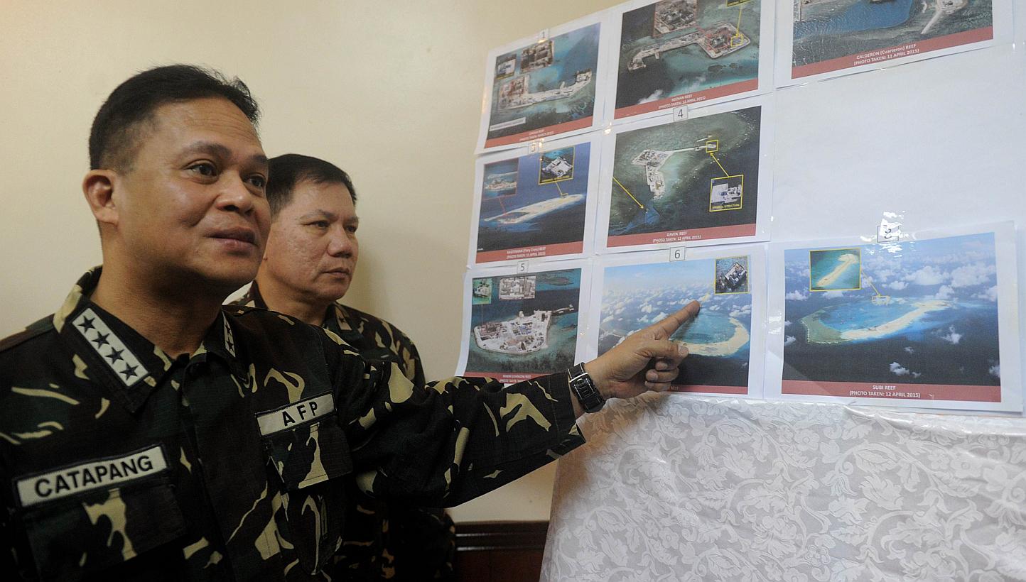 Filipino military chief Gregorio Catapang pointing to aerial photos of Chinese construction over reefs and shoals in the Spratly archipelago during a press briefing in Manila last month. The Philippines has expressed alarm about China's reclamation a