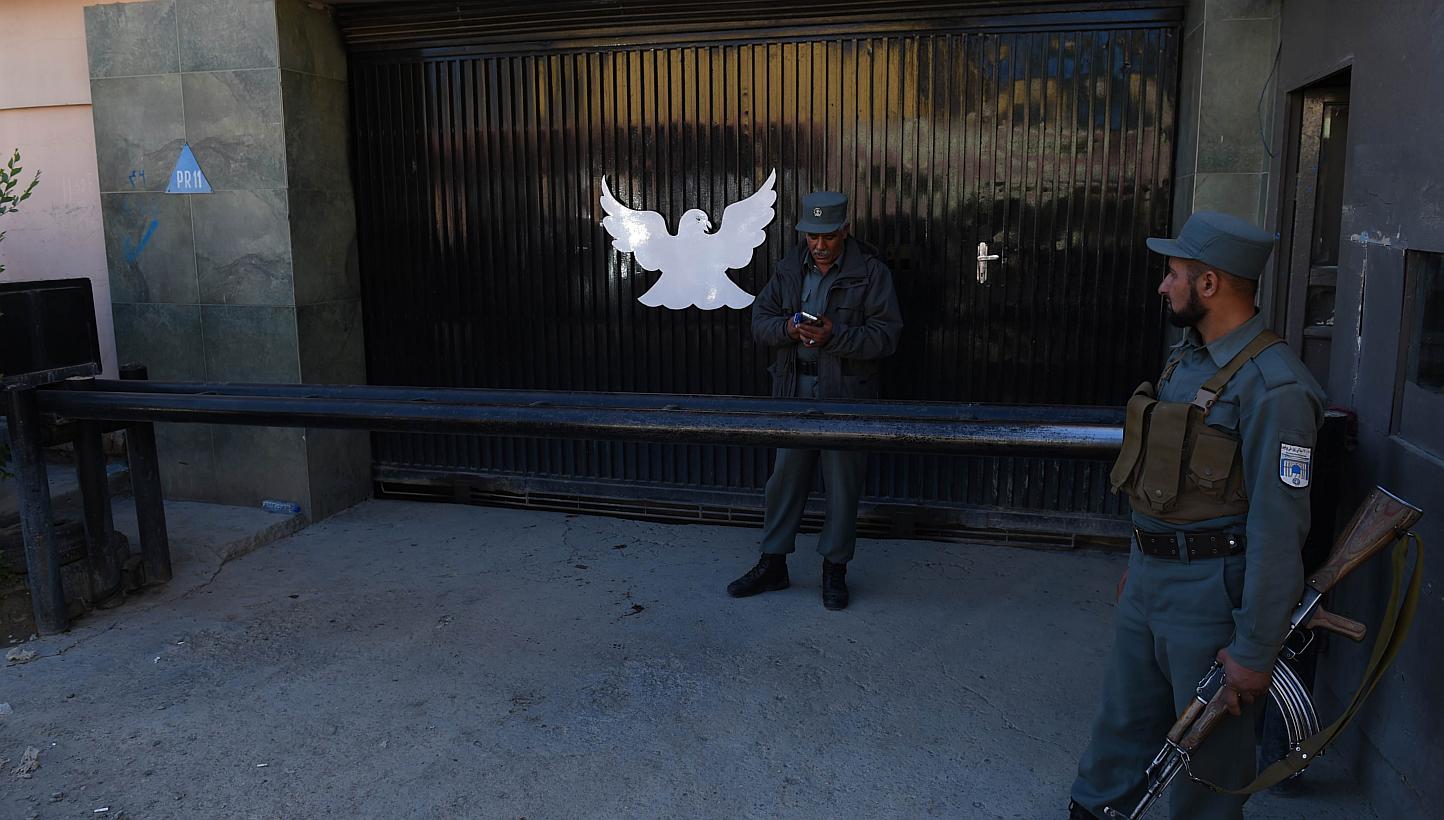 Afghan policemen stand guard at the entrance of the Park Palace guesthouse in Kabul on May 14, 2015. -- PHOTO: AFP&nbsp;