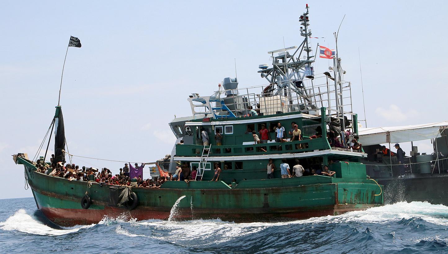 A boat with migrants is being towed away from Thailand by a Thai navy vessel, in waters near Koh Lipe island on May 16, 2015. -- PHOTO: REUTERS