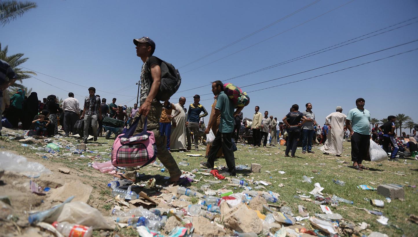 Displaced Iraqis who were forced to flee their hometowns ahead of gains made by Islamic State in Iraq and Syria (ISIS) militants in Ramadi, western Iraqi, wait near the Bzebiz bridge crossing the Euphrates River on their way to Baghdad, Iraq on May 1