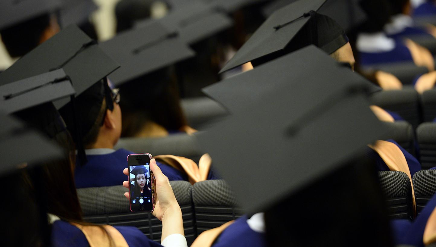 A student at NUS taking a selfie on July 7, 2014. A Malaysian photography student from Universiti Teknologi Mara was suspended after he took a selfie onstage during his graduation ceremony. -- ST PHOTO: MARK CHEONG