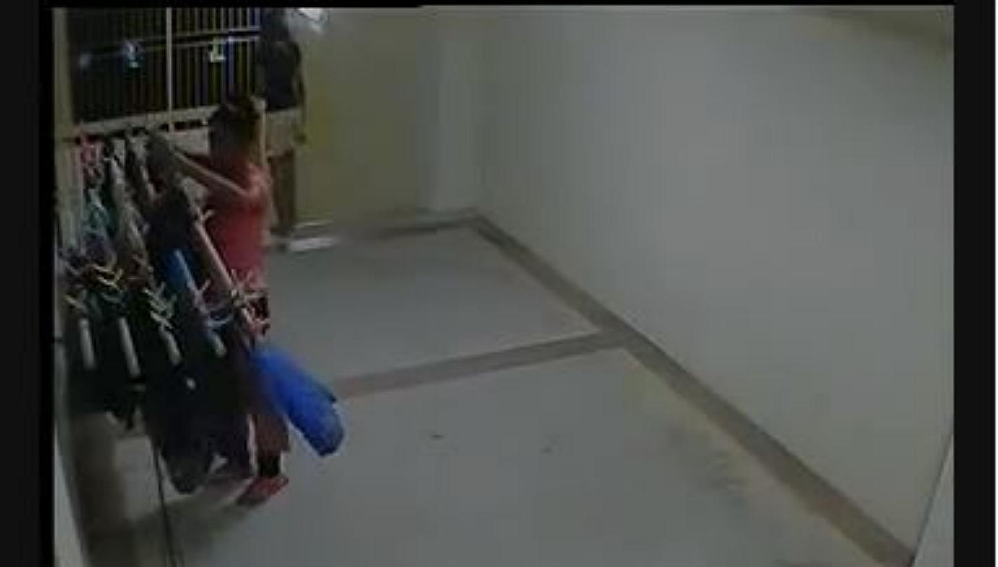 A screengrab of CCTV footage showing one girl allegedly stealing from a clothes rack at a Housing Board corridor while another girl acts as a lookout. -- FACEBOOK/ALLSGSTUFF 