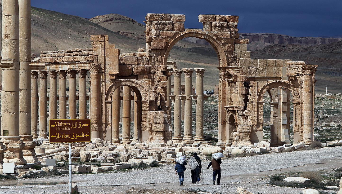 A file picture taken in March 2014 shows Syrian citizens walking in the ancient oasis city of Palmyra, 215km north-east of Damascus. -- PHOTO: AFP