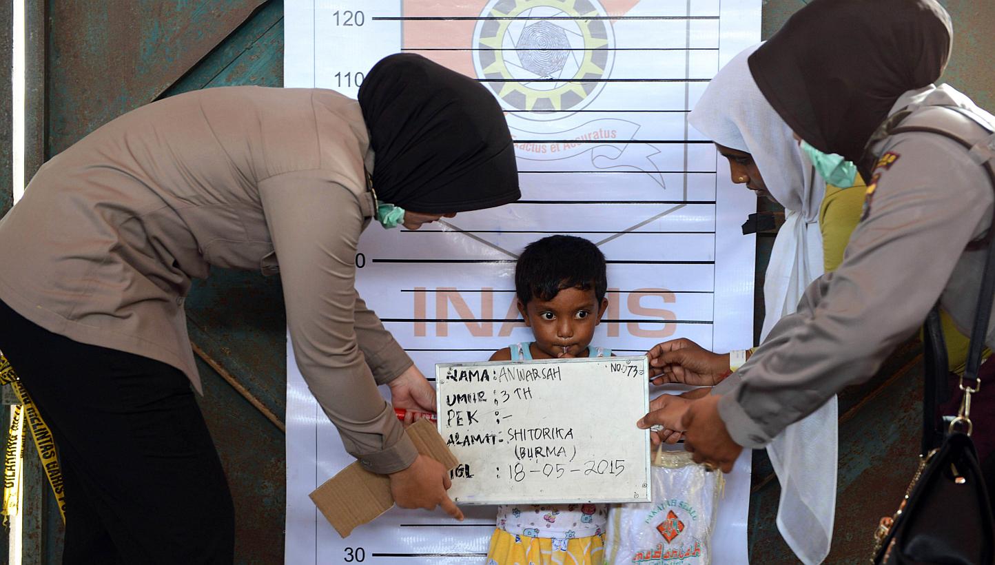 A Rohingya boy from Myanmar is photographed during an Indonesian police identification process at the confinement area in the fishing port of Kuala Langsa in Aceh province on May 18, 2015. -- PHOTO: AFP 