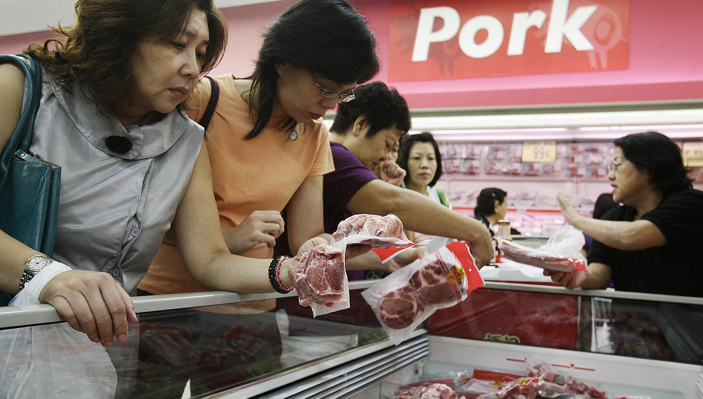 Shoppers looking over frozen pork products at NTUC Fairprice in Ang Mo Kio Hub. The Agri-Food & Veterinary Authority (AVA) recently approved the import of frozen pork from a slaughterhouse in Sarawak, marking the partial end of a more-than-decade