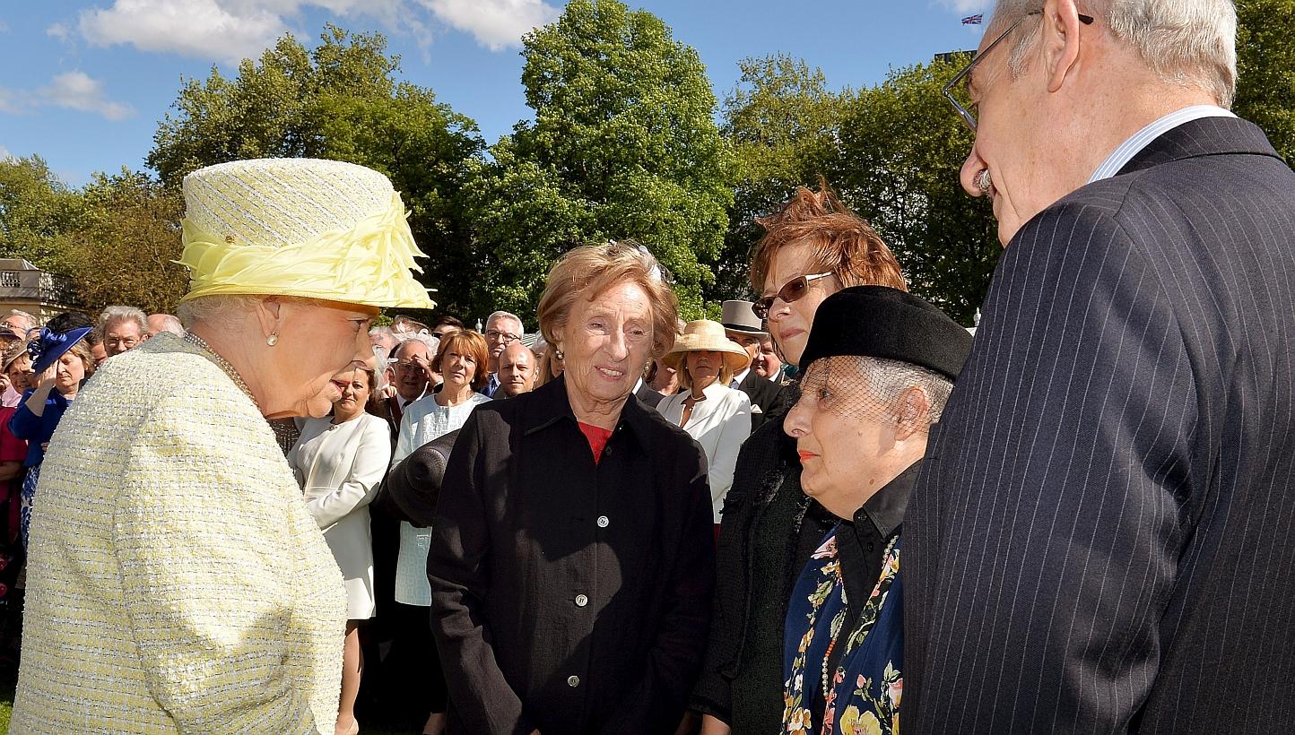 Britain's Queen Elizabeth II (left) talks to Holocaust survivors (left to right) Susan Pollock, her daughter Sandra Gee, Cirla Lewis, also a survivor and her husband Phillip Lewis during a garden party held at Buckingham Palace, in London on May 12.
