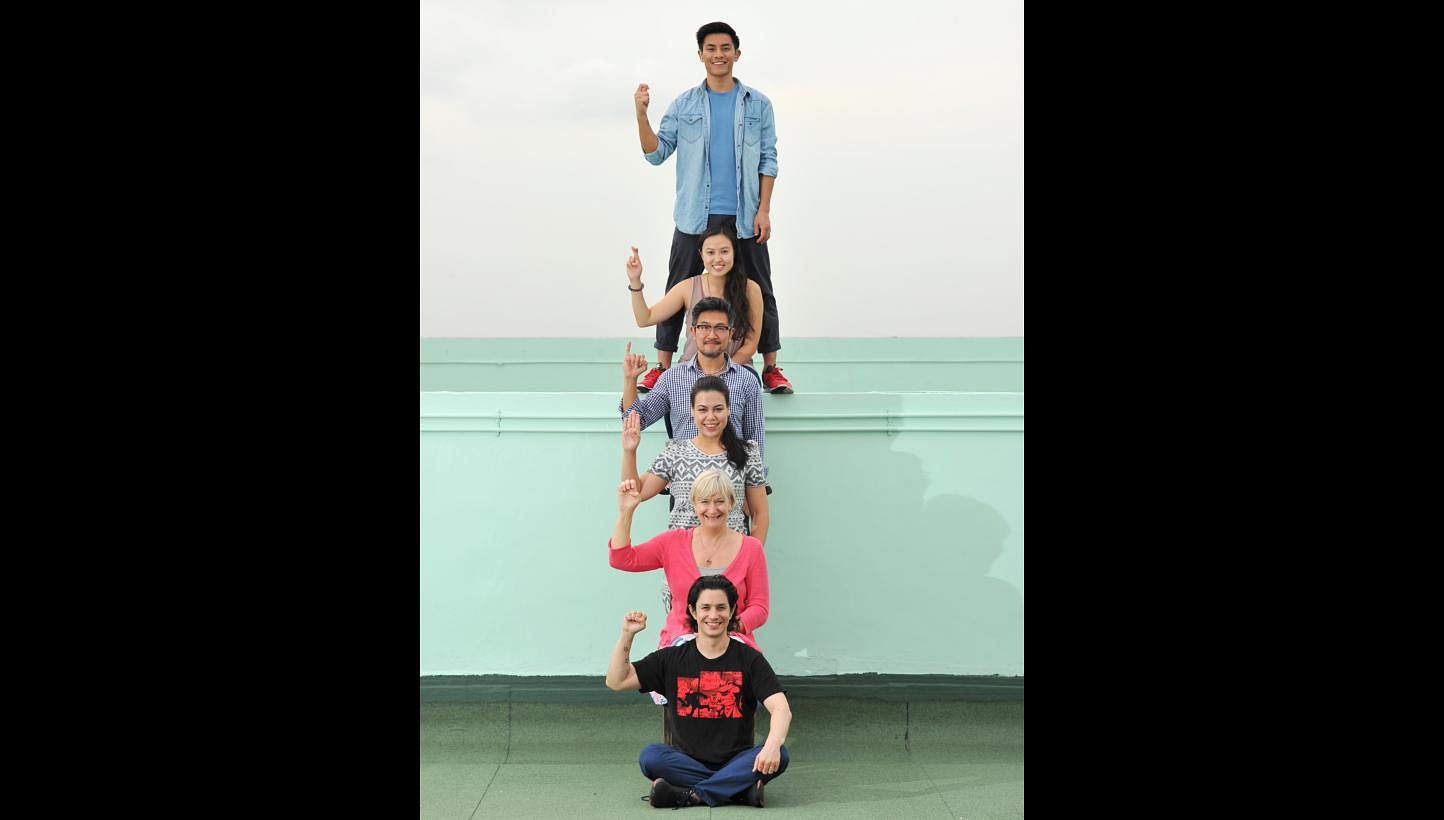 Cast of Tribes spelling the play’s title by sign language: (from top) Thomas Pang, Ethel Yap, Adrian Pang, Frances Lee, Susan Tordoff and Gavin Yap. -- PHOTO: LIM YAOHUI FOR THE STRAITS TIMES
