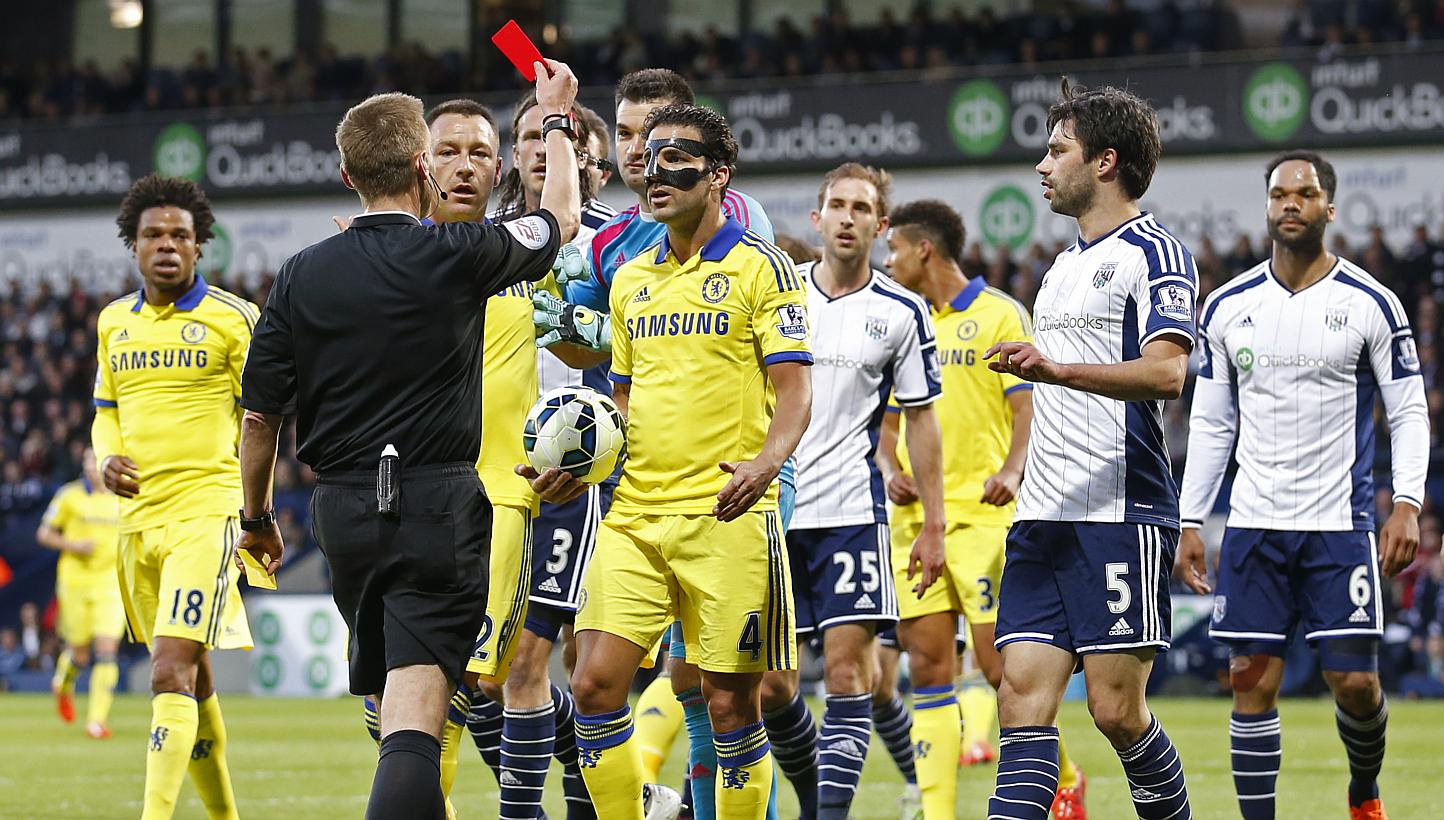 Chelsea midfielder Cesc Fabregas (in mask) being shown a red card by referee Mike Jones during his team's 3-0 defeat to West Brom. -- PHOTO: REUTERS 