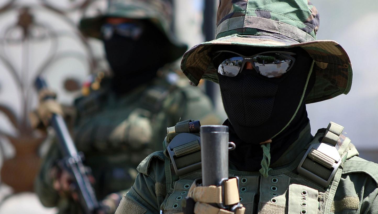 Iraqi fighters of the Shiite militia Asaib Ahl al-Haq (The League of the Righteous) stand guard outside their headquarters on Monday in the Iraqi mainly Shiite southern city of Basra, as Shiite militias converged on Ramadi in a bid to recapture it. -