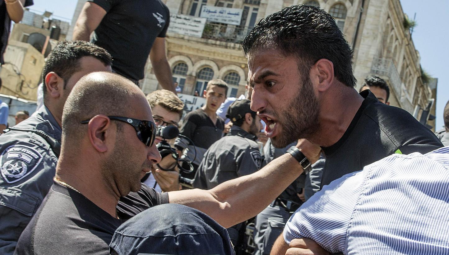 Palestinian demonstrators are confronted by Israeli police during the Israeli "flag march" through Damascus Gate in Jerusalem's old city during celebrations for Jerusalem Day on May 17, 2015. Two Israeli policemen were wounded in annexed east Jerusal