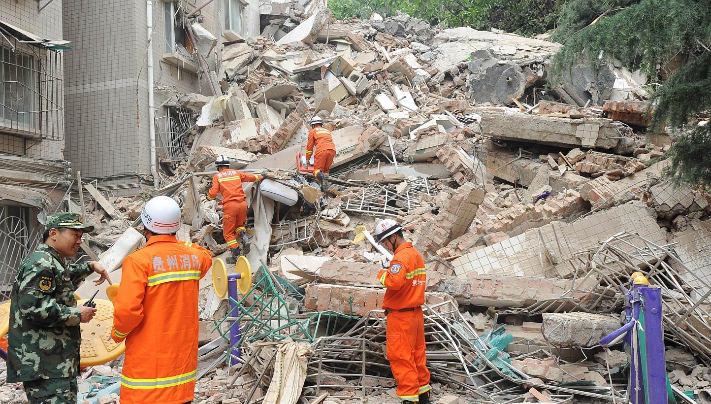 Rescuers look for survivors in the ruins of a collapsed nine-storey residential apartment in Guiyang, south-west China's Guizhou province on May 20, 2015.&nbsp;At least 15 people were believed to be missing on Wednesday afterthe building collapsed du