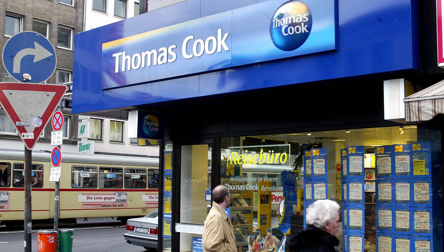 Pedestrians pass a Thomas Cook travel agency ocation in Duesseldorf, Germany on November 18, 2002. Travel firm Thomas Cook expressed regret on Wednesday for the deaths of two British children on one of its holidays in 2006, seeking to
