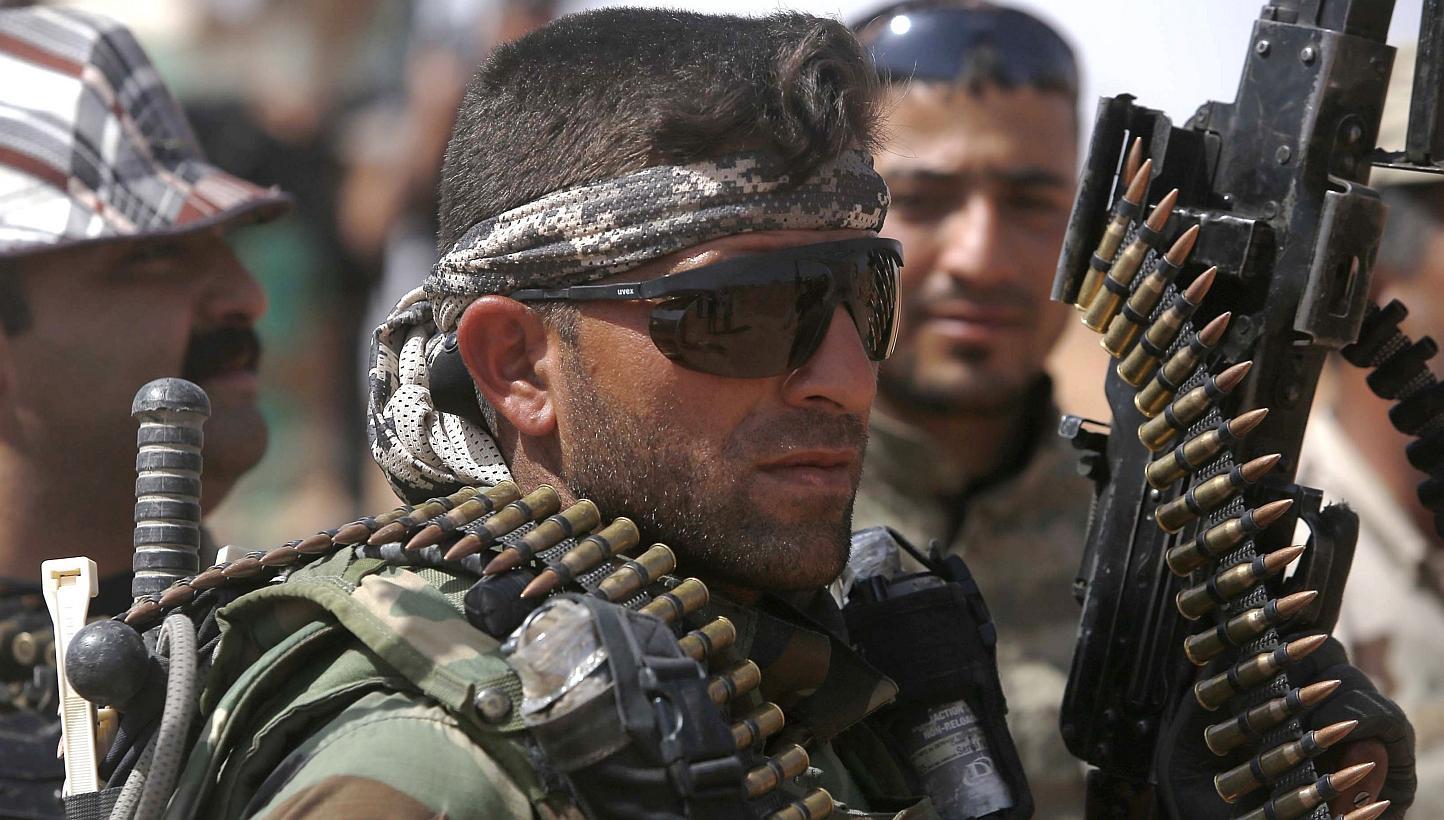 An Iraqi fighter from the Shiite Muslim Al-Abbas popular mobilisation unit holds a weapon in the area surrounding the village of Nukhayb in the embattled Anbar province west of the capital Baghdad, on Tuesday. Iraq's army and allied paramilitary forc