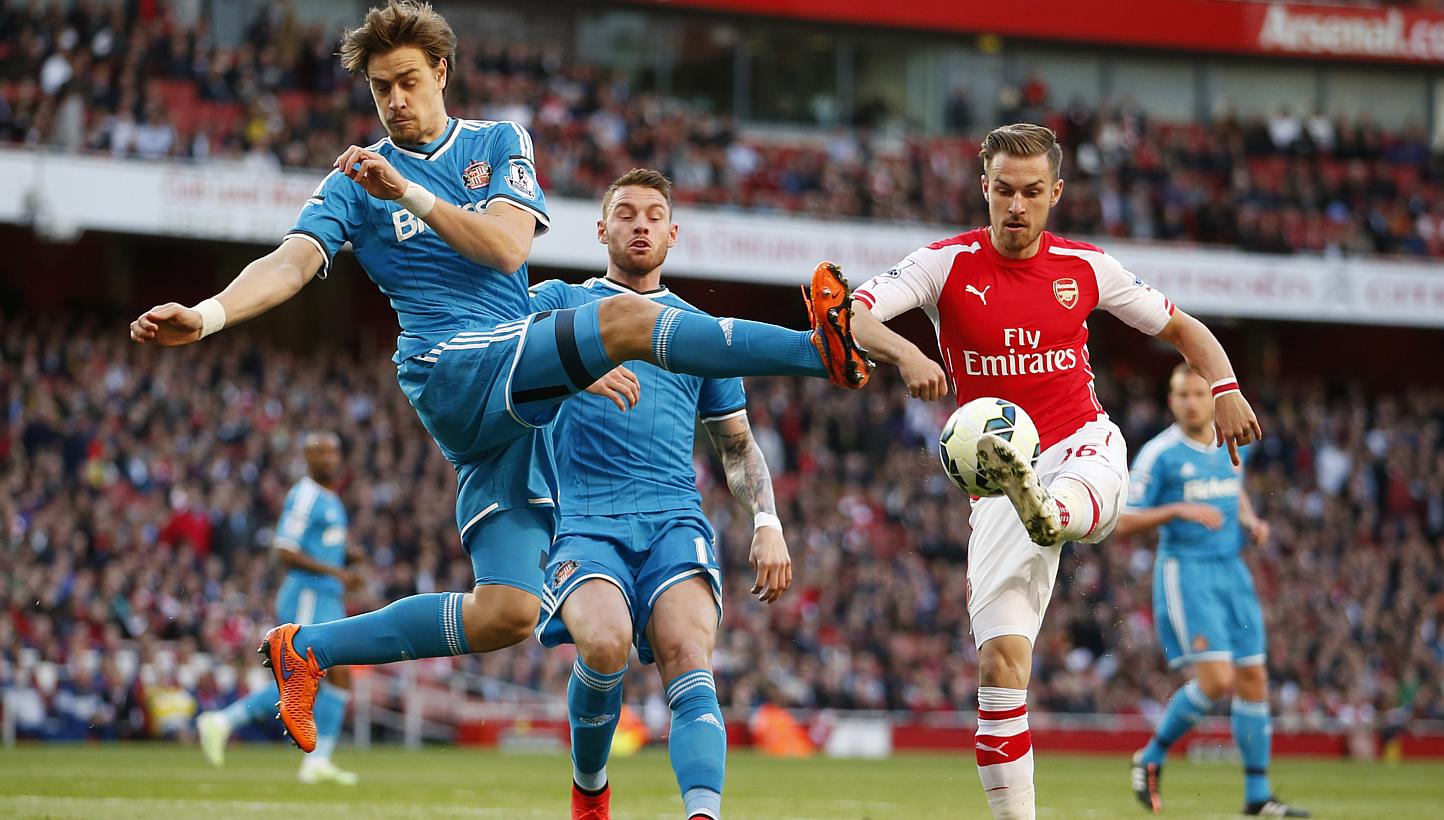 Sunderland defender Sebastian Coates (left) attempts to win the ball from Arsenal midfielder Aaron Ramsey (right) in their 0-0 draw at the Emirates Stadium in London. -- PHOTO: REUTERS&nbsp;