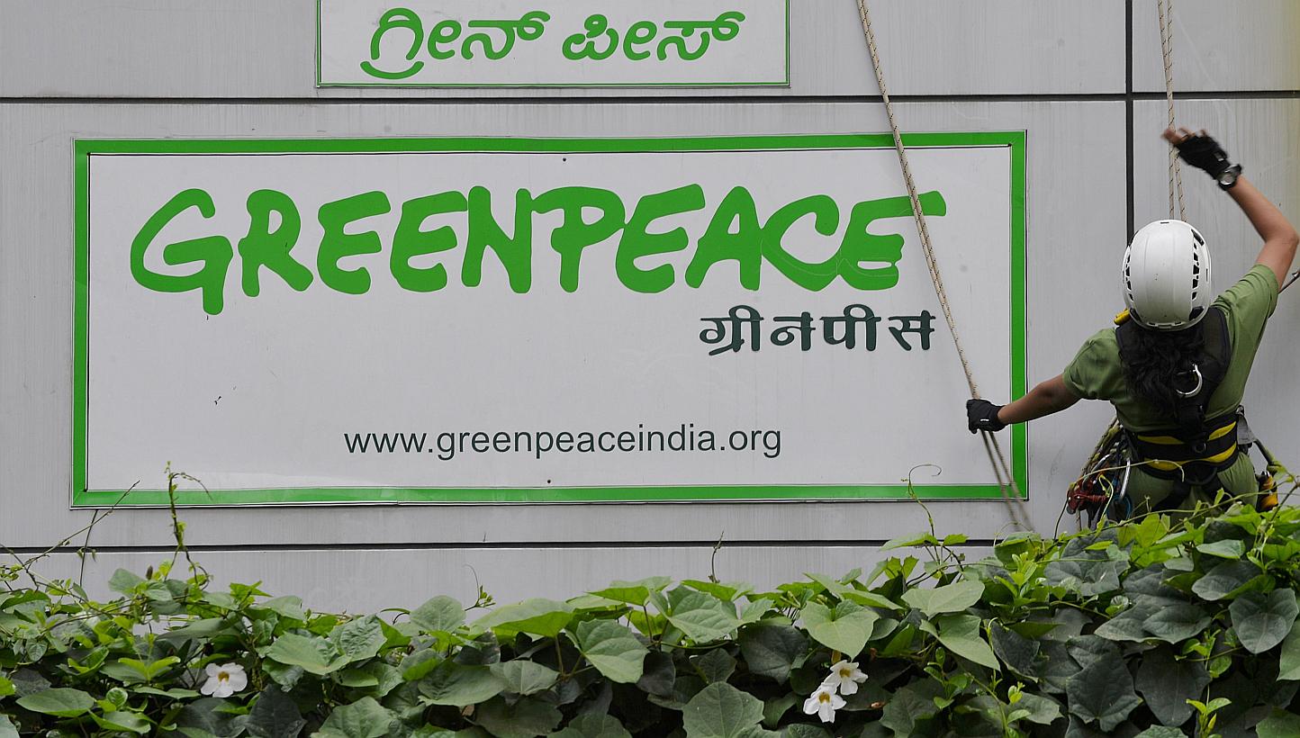 Activists of GreenPeace rappel down their office building to unfurl banners that read 'democracy' and 'freespeech' in Bangalore on May 15, 2015. Greenpeace is determined to keep operating in India even after the federal government froze its bank acco