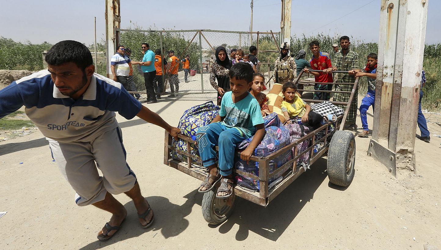 Iraqi residents from the city of Ramadi, who fled their homes as Islamic State militants tightened their siege on the last government positions in the capital of Anbar province, wait to cross Bzeibez bridge, on the southwestern frontier of Baghdad, o