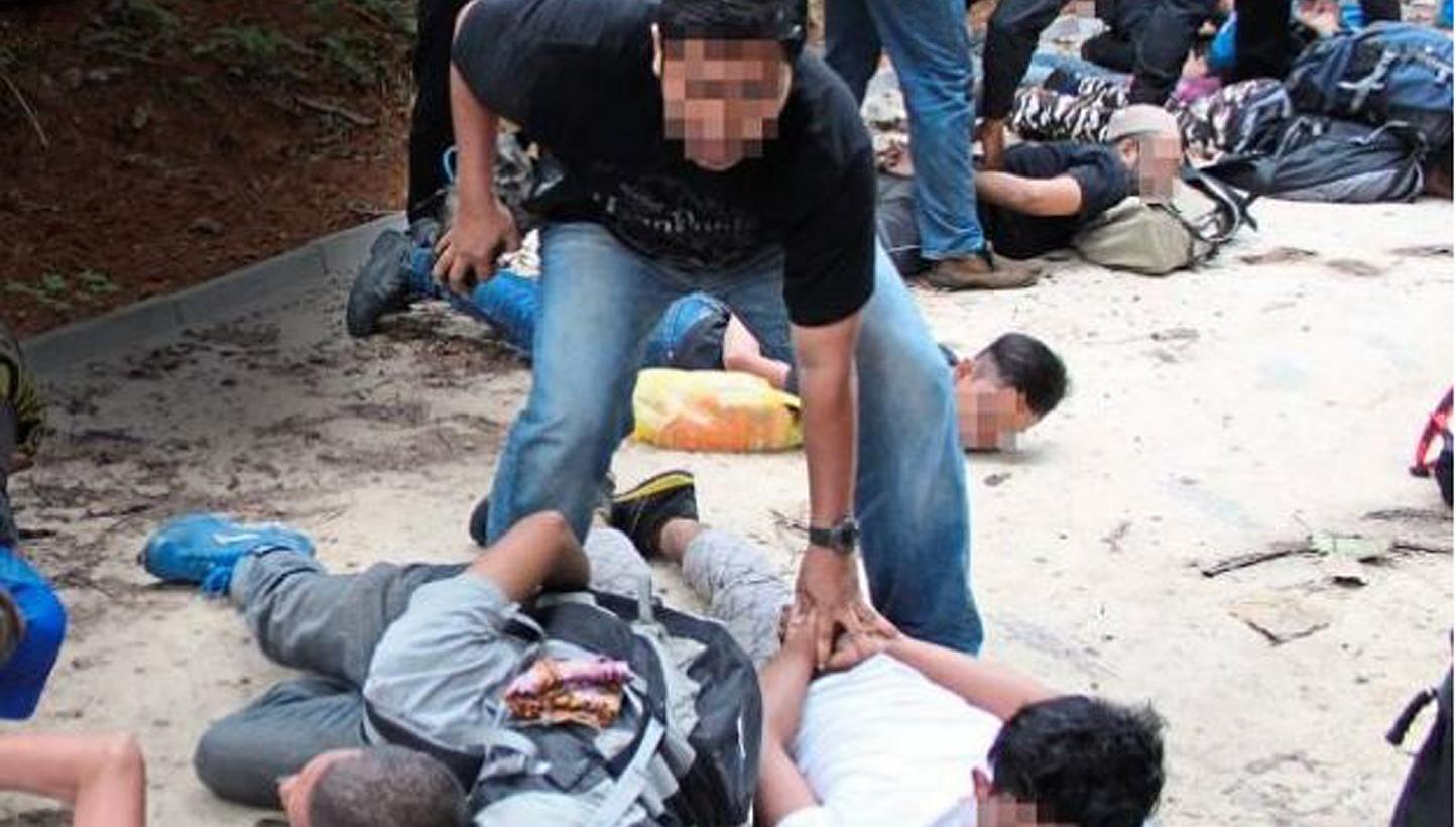 Bukit Aman’s Special Branch Counter Terrorism Division detaining 11 men at the foothills of Hutan Lipur Gunung Nuang on April 25, 2015. -- PHOTO: THE STAR