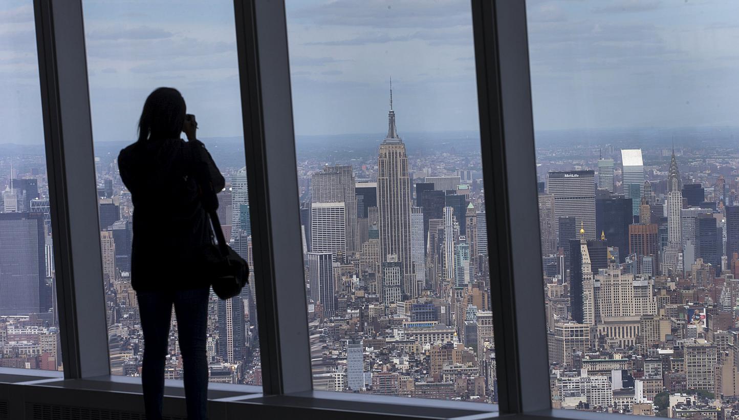 A woman photographs the Manhattan skyline from the One World Observatory on the 100th floor of the One World Trade center tower in New York during a press tour of the site May 20, 2015. One World Observatory will open to the public on May 29. -- PHOT