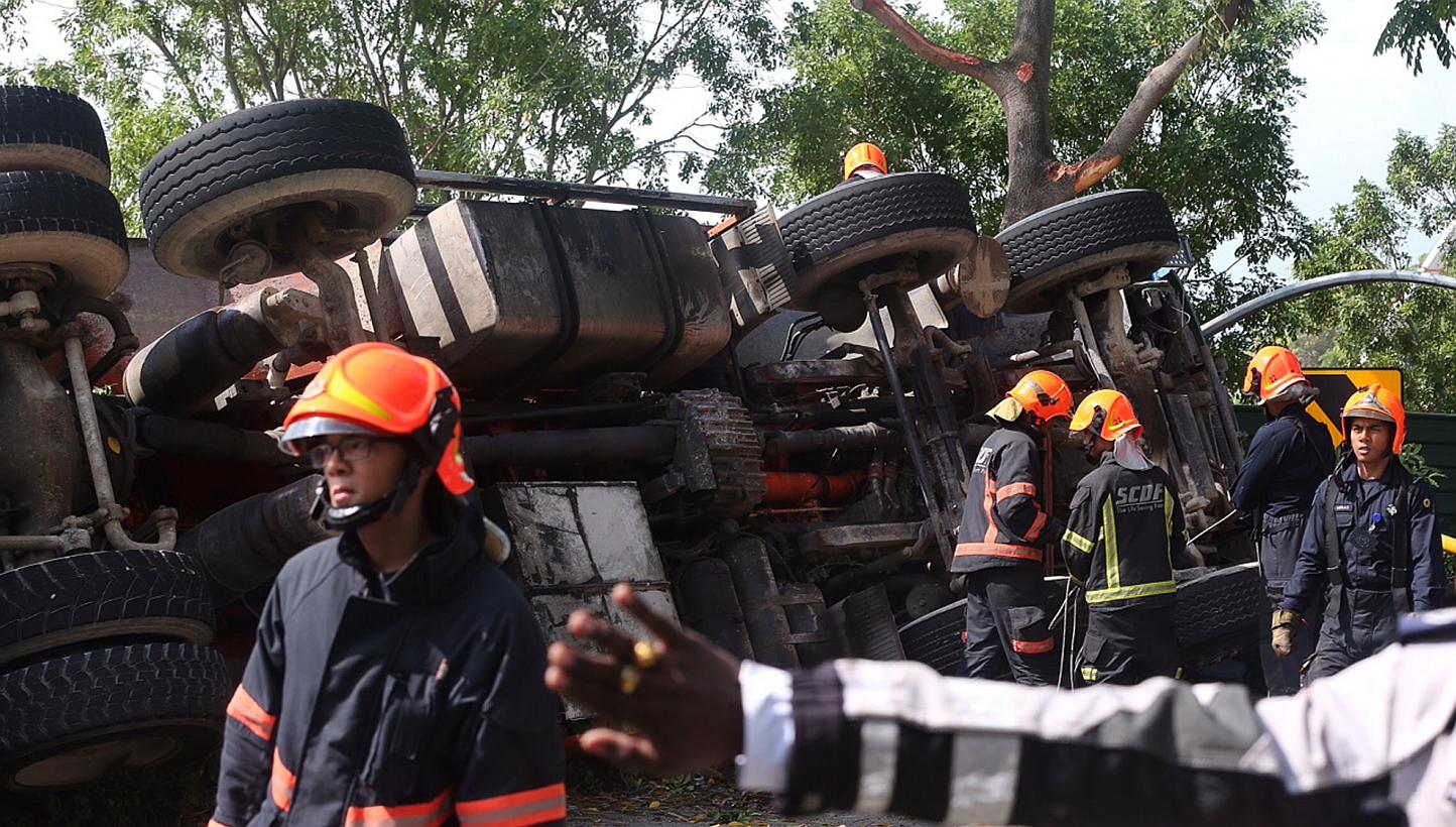 A trailer toppled on its left on a filter road on Airport Boulevard towards the PIE heading to the city on May 20, 2015. The driver of the trailer, who was trapped inside the vehicle, was rescued at about 10.20am and taken to the hospital. -- ST PHOT