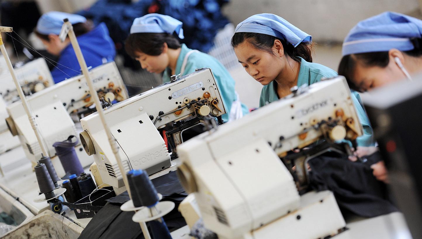 Workers producing clothes in a factory in Huaibei, east China's Anhui province, on May 19, 2015. China's factory activity contracted for the third straight month in May, which together with a lacklustre performance from Japan and alarmingly weak expo