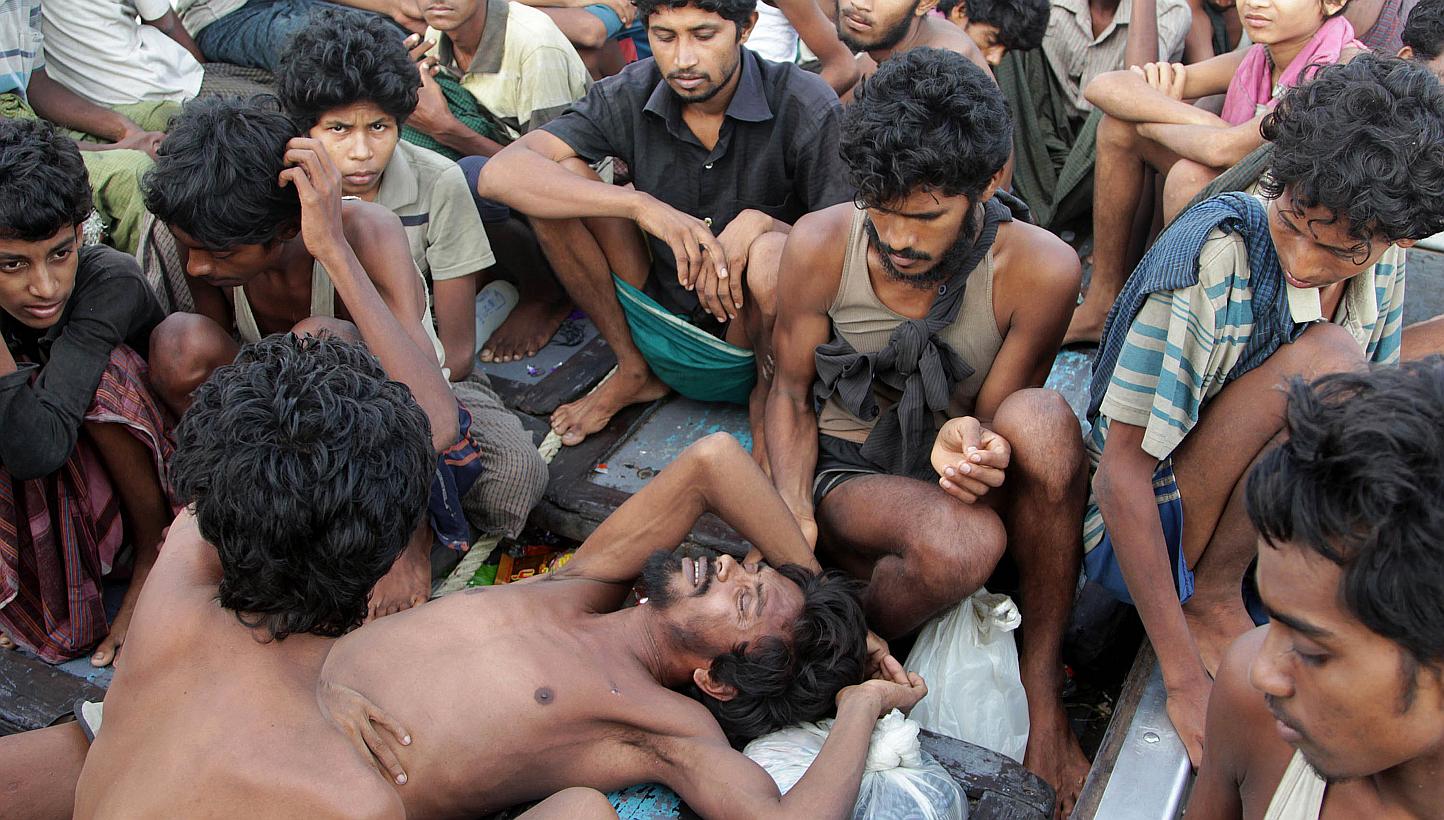 Rohingya migrants sit in a boat off the coast near the city of Geulumpang in Indonesia's East Aceh district of Aceh province before being rescued on May 20, 2015. -- PHOTO: AFP