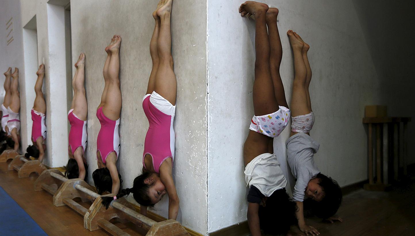 Students practice at the gymnastics hall of a sports school in Jiaxing, Zhejiang province, on May 20, 2015. Young gymnasts, from 6 to 11-year-old, train everyday for at least 5-hours. -- PHOTO: REUTERS