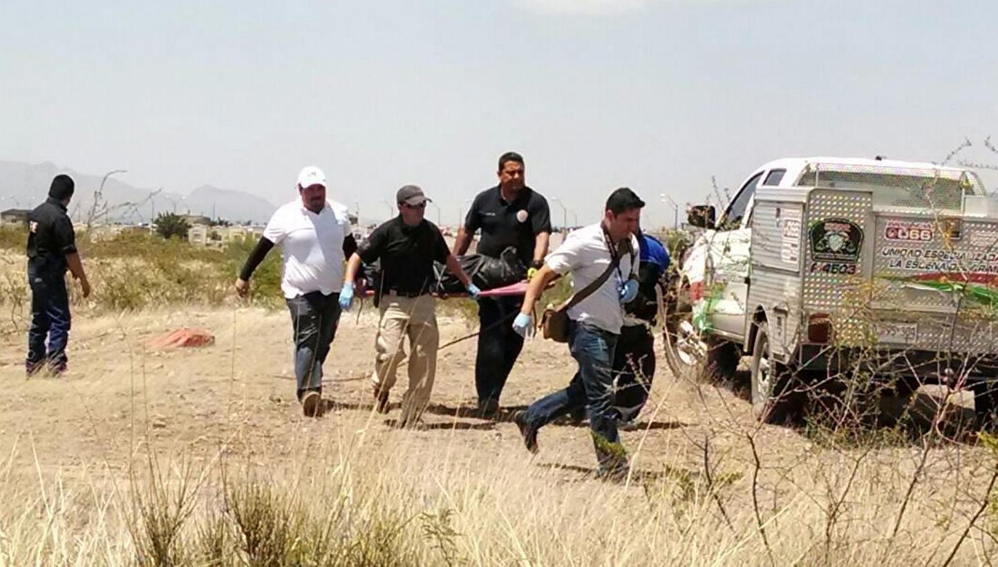 Mexican forensics carrying the dead body of a six-year old child, who was killed by minors, in Chihuahua state, Mexico, on May 19, 2015. -- PHOTO: EPA