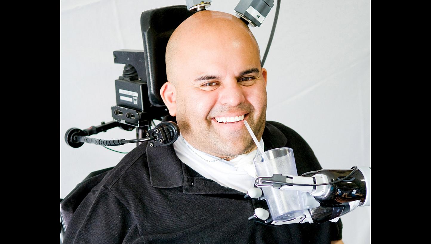 Erik Sorto, 34, who was paralysed from the neck down at age 21 after a gunshot wound, can now make a hand-shaking gesture, grab a cup to drink from and even play "rock, paper, scissors" with his robotic arm. -- PHOTO: REUTERS