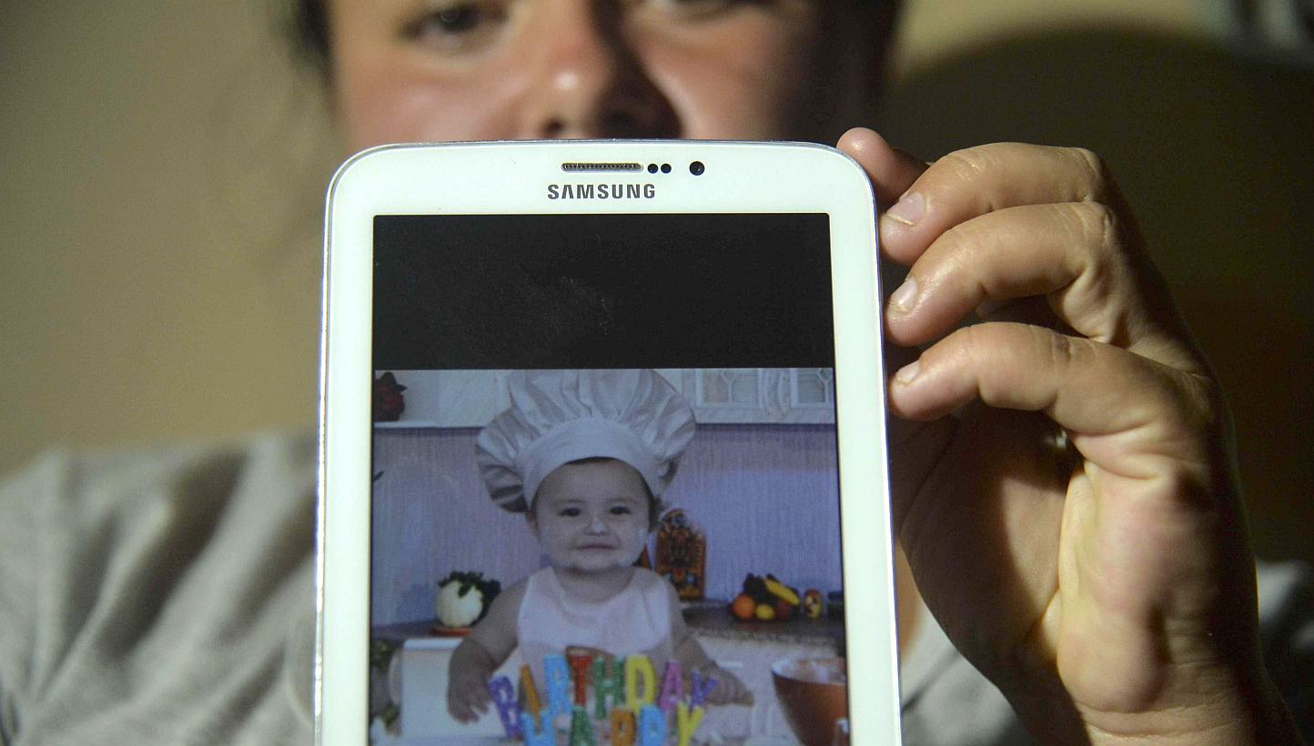 Colombian Natalia Rincon shows a picture on May 20, 2015, of baby Jhoset Diaz, who survived a massive landslide that tore through a ravine in north-west Colombia on Monday before dawn, killing at least 83 people and injuring 40. -- PHOTO: AFP&nbsp;
