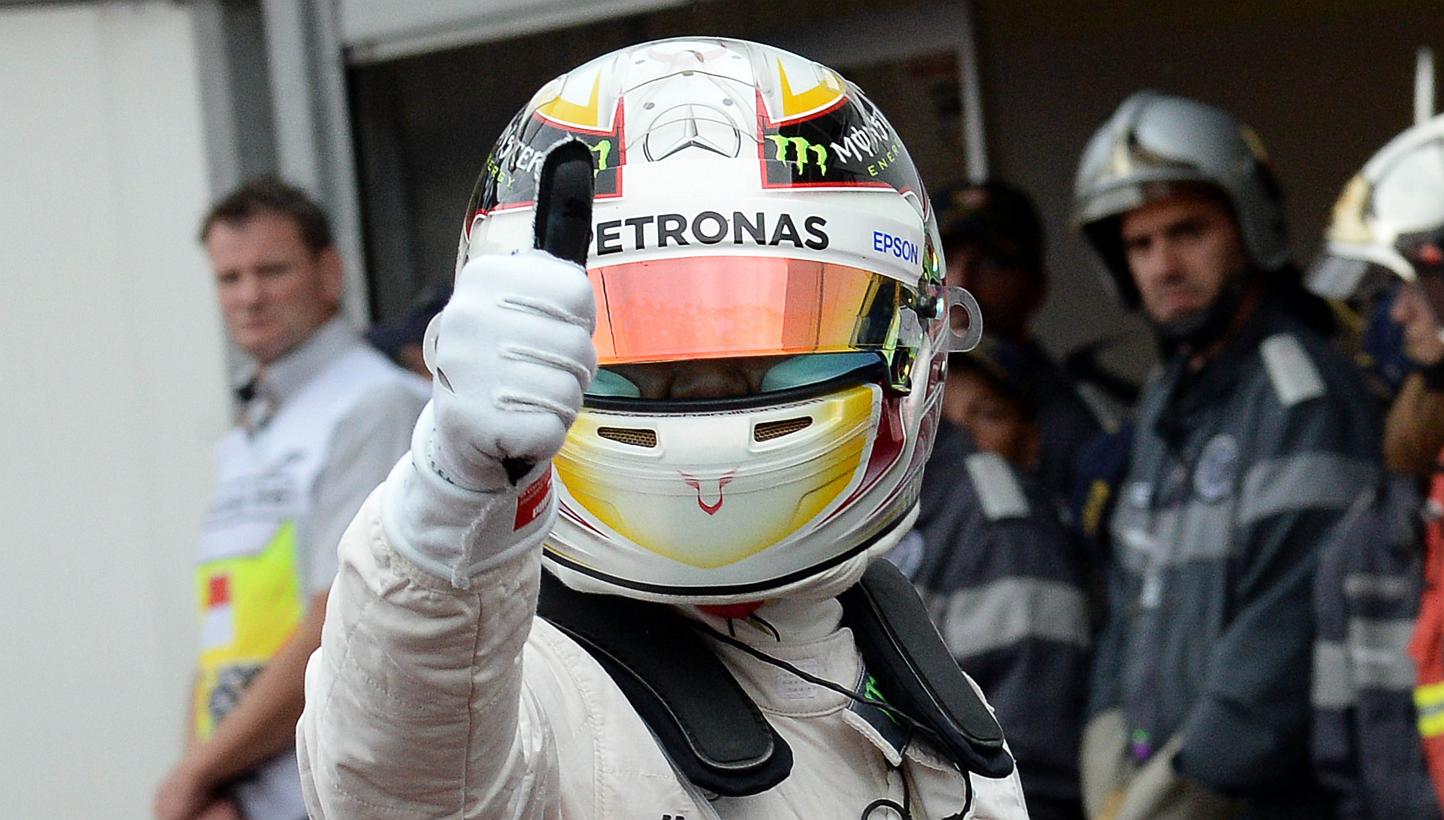 Mercedes AMG Petronas F1 Team's British driver Lewis Hamilton (R) gives the thumbs up as he celebrates taking the pole position in the pits after after the qualifying session at the Monaco street circuit in Monte-Carlo on May 23, 2015. -- PHOTO: AFP
