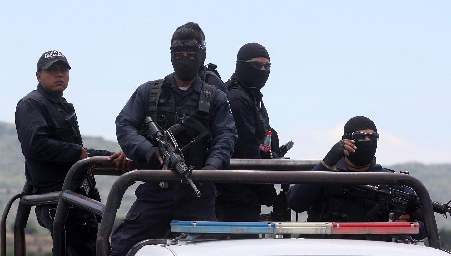 Federal police officers leave the ranch where gunmen took cover during an intense gun battle with the police, along the Jalisco-Michoacan highway in Vista Hermosa, Michoacan State, on May 22, 2015. -- PHOTO: AFP