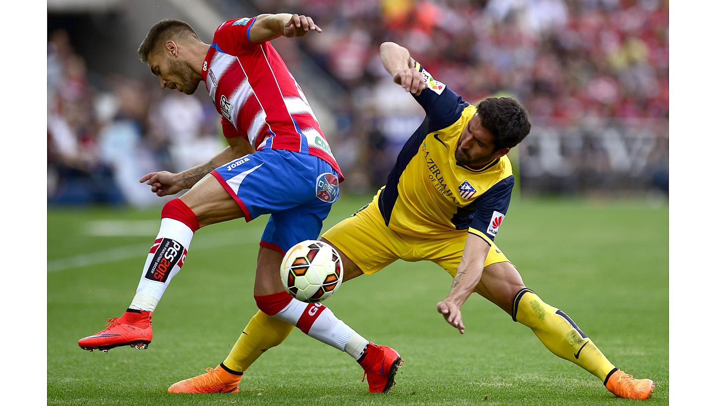 Granada's forward Ruben Rochina (left) vies with Atletico Madrid's midfielder Raul Garcia on May 23, 2015. -- PHOTO: AFP&nbsp;