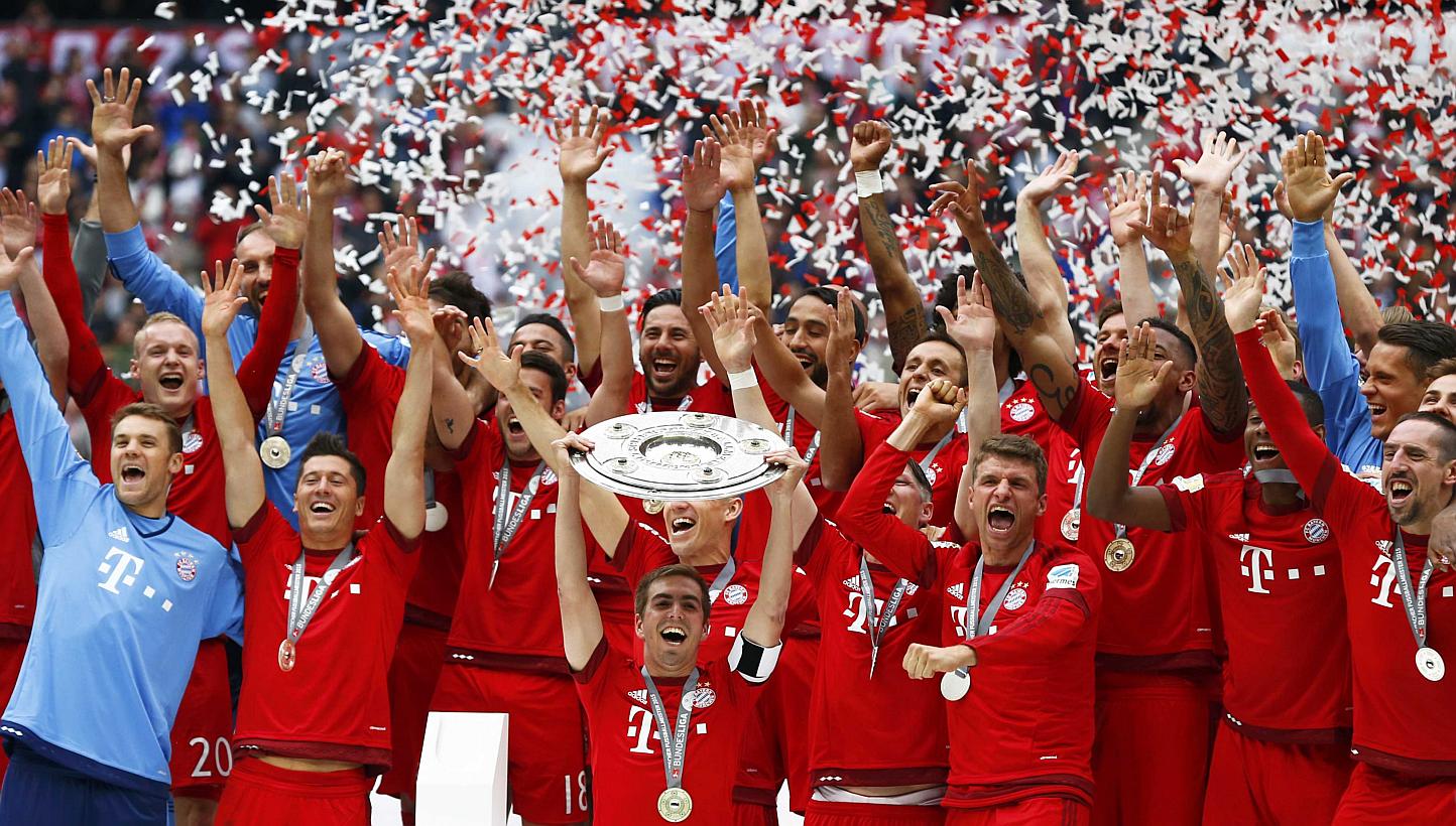 Bayern Munich's Philipp Lahm lifts up the trophy after their final Bundesliga match of the season against Mainz in Munich, on May 23, 2015. -- PHOTO: REUTERS