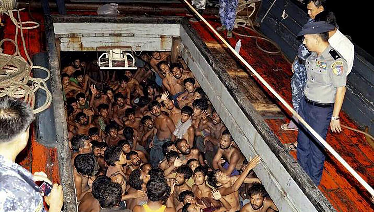 A handout photo provided by the Myanmar Information Ministry shows Myanmar police officers on a fishing boat with migrants, most of them from Bangladesh, according to a government website,&nbsp;near the coast of Rakhine, Myanmar on May 22, 2015. -- P