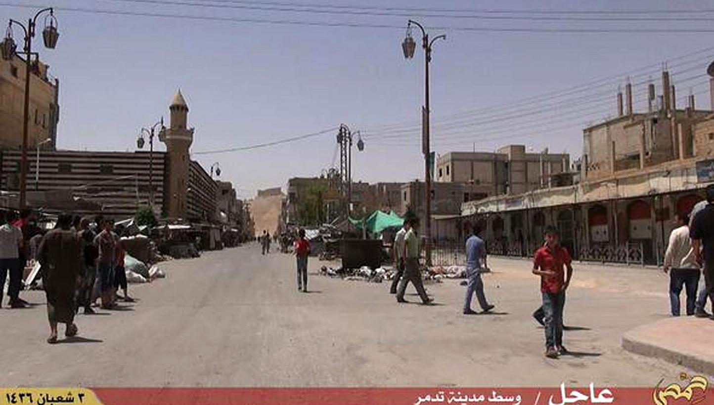 An image grab taken from a video made available by Jihadist media outlet Welayat Homs on May 21, 2015 allegedly shows people walking in a street of Syria's ancient city of Palmyra after the Islamic State in Iraq and Syria (ISIS) seized it. -- PHOTO: 