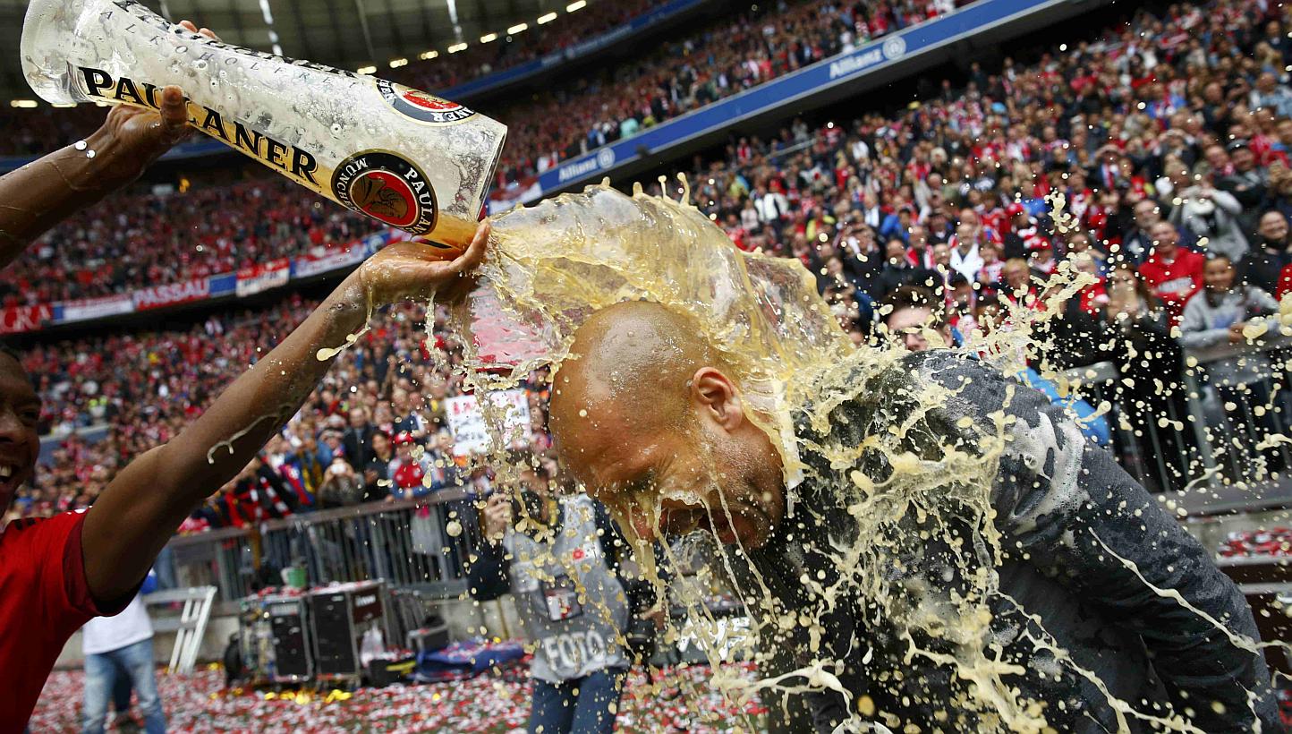 Bayern Munich's David Alaba (left) pours beer over coach Pep Guardiola after their final Bundesliga match of the season against Mainz on May 23, 2015. -- PHOTO: REUTERS