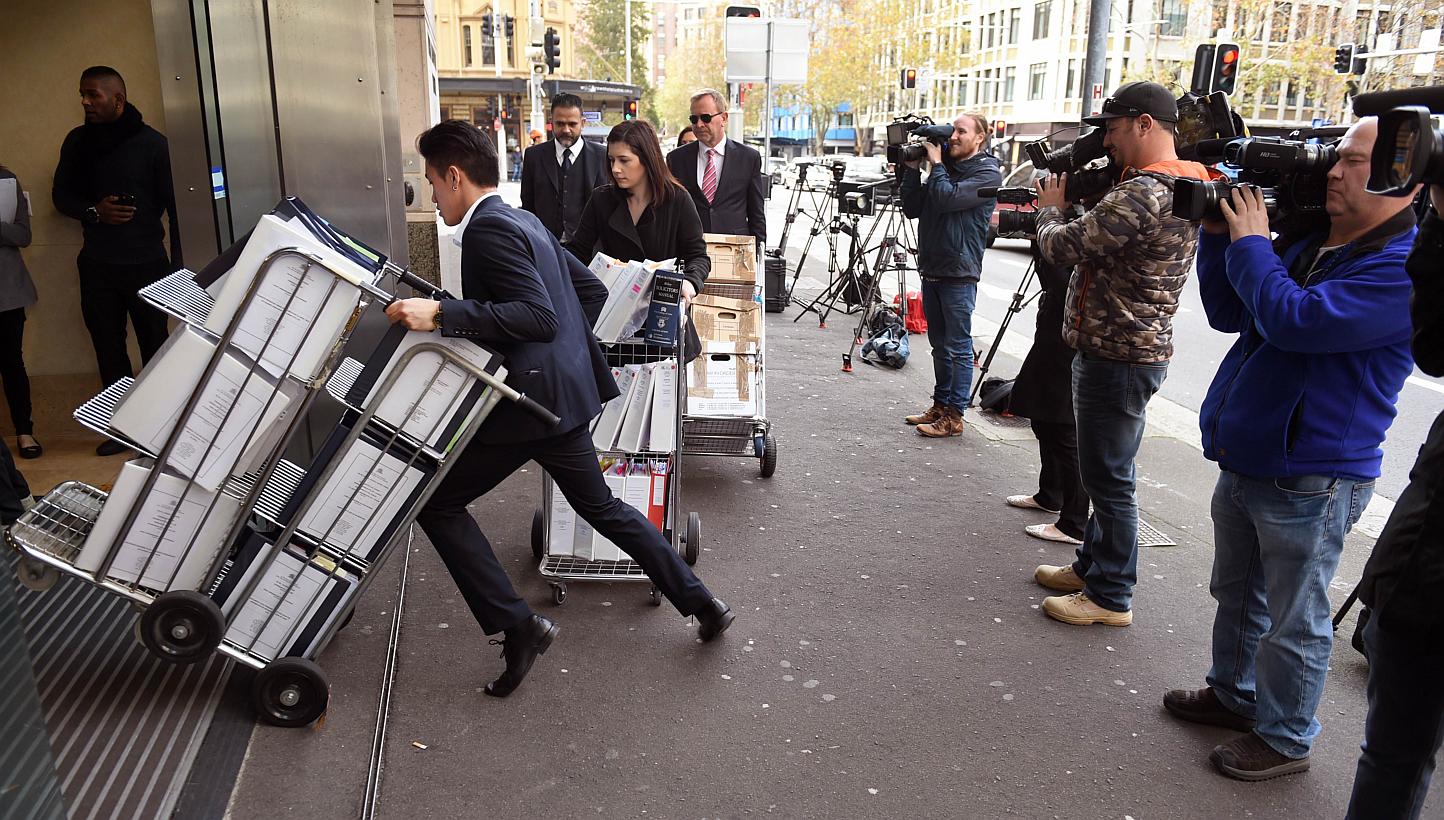Television crews (right) film people entering the building in Sydney on May 25, 2015, where an inquest into the deaths arising from the Lindt Café siege is being held. -- PHOTO: AFP&nbsp;