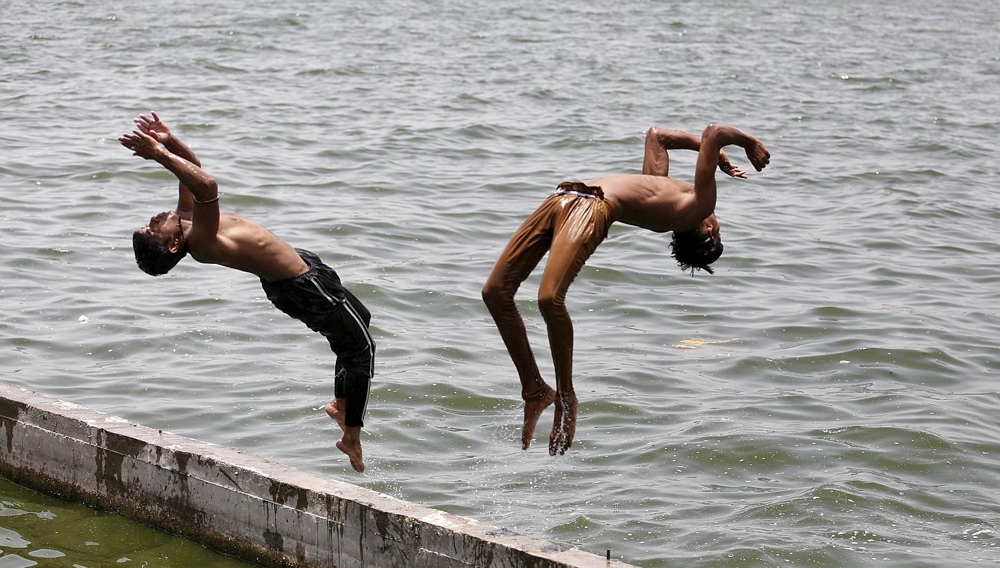Boys jumping into the Sabarmati river in Ahmedabad yesterday to cool off. Temperatures in the city yesterday reached 43 deg C, according to the India Meteorological Department website. -- PHOTO: EUROPEAN PRESSPHOTO AGENCY