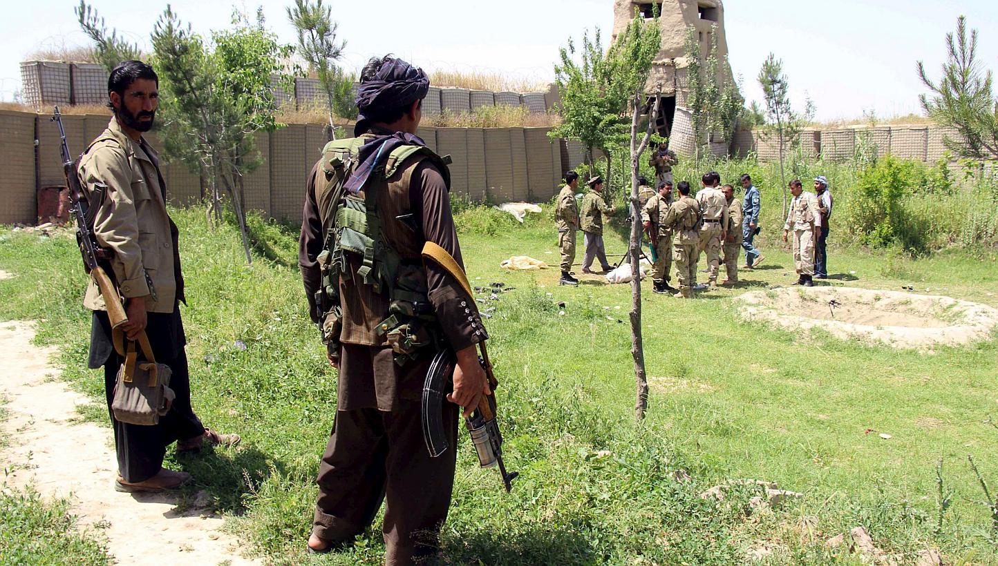 Afghan militias and policemen gather as they discuss during a battle against Taleban militants at the Chardara district of Kunduz province, May 3, 2015. About 40 people were wounded on Monday when a Taleban suicide bomber detonated a truck carrying a