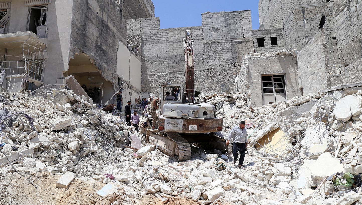 People inspect the rubble of collapsed buildings following a reported airstrike by government forces on May 24, 2015, in the rebel-held al-Sukari neighborhood of the northern city of Aleppo. Home Minister Datuk Seri Dr Ahmad Zahid Hamidi reassured Ma