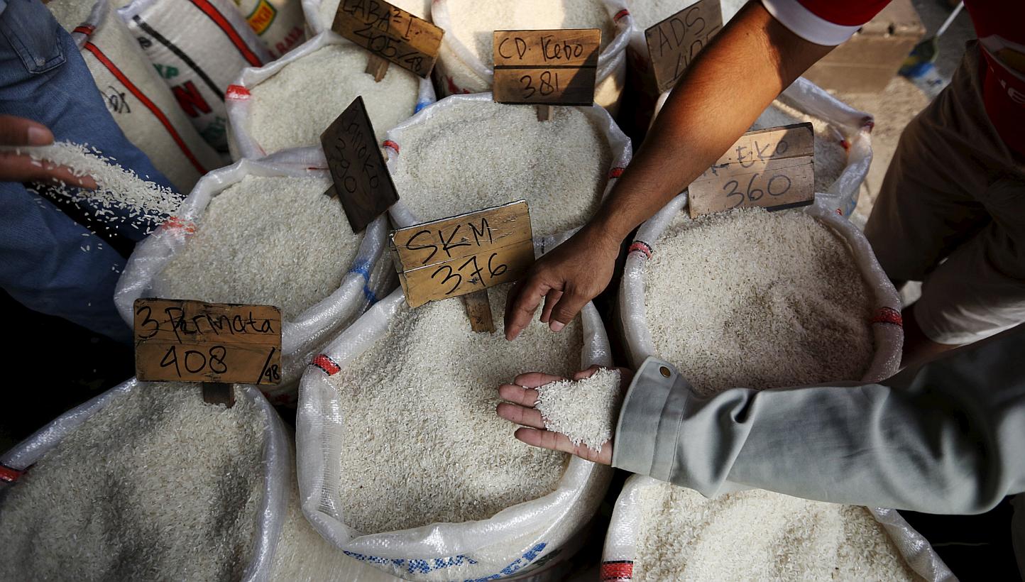 Customers check the quality of rice before buying at a wholesale rice market in East Jakarta, Indonesia, on May 20, 2015. Indonesia's home minister Tjahjo Kumolo called for a police investigation into the suspected contamination of rice wit