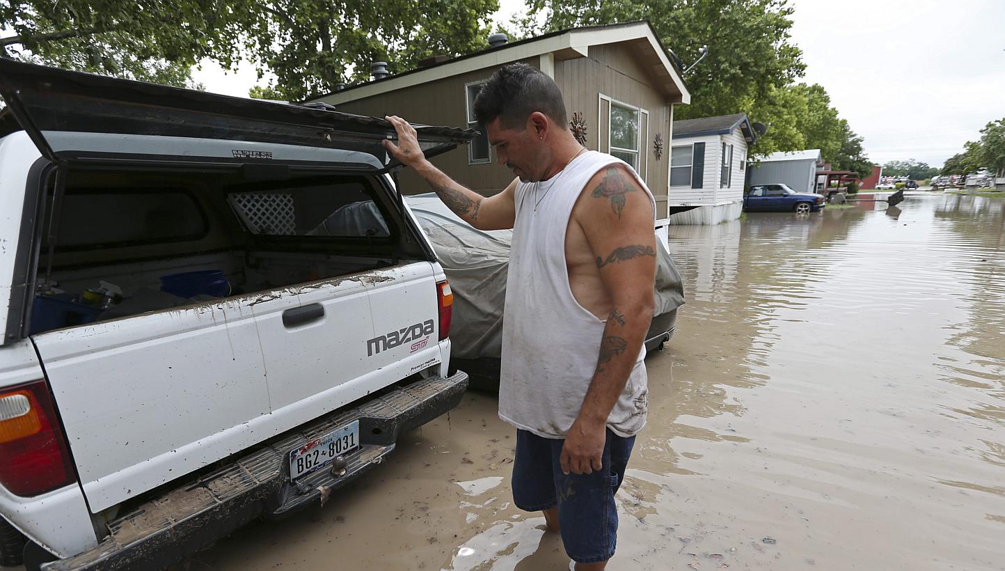 San Marcos resident Keith Varela checks out the damage done to his wife's truck in the San Marcos Mobile Home Park in San Marcos, Texas, on May 24, 2015.&nbsp;Rescuers searched on Monday, May 25, for at least 12 people missing in spectacular flash fl