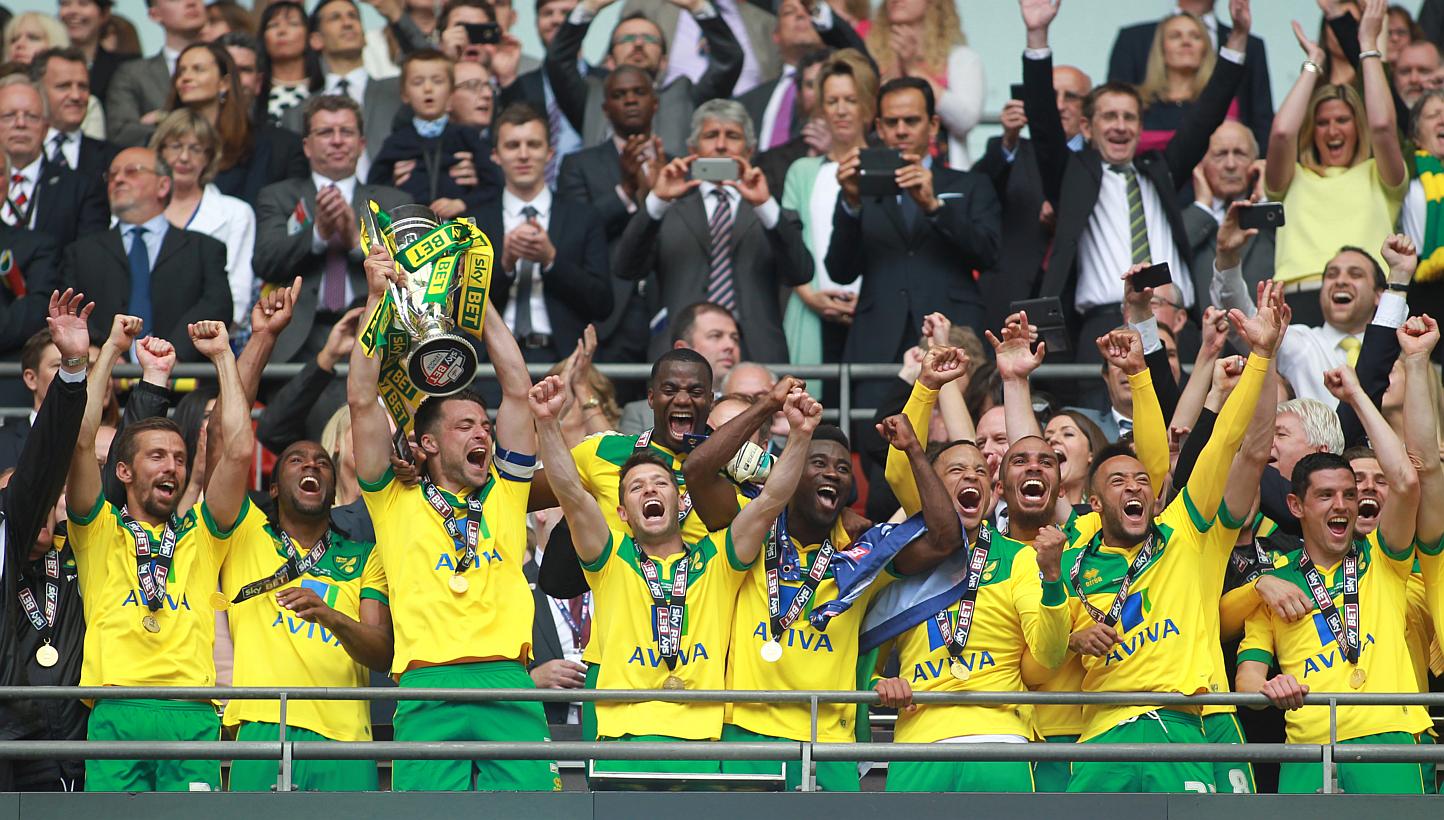 Norwich City's Russell Martin lifts the trophy as they celebrate gaining promotion to the Barclays Premier League after beating Middlesbrough 2-0 in the Championship play-off final at Wembley Stadium. -- PHOTO: REUTERS